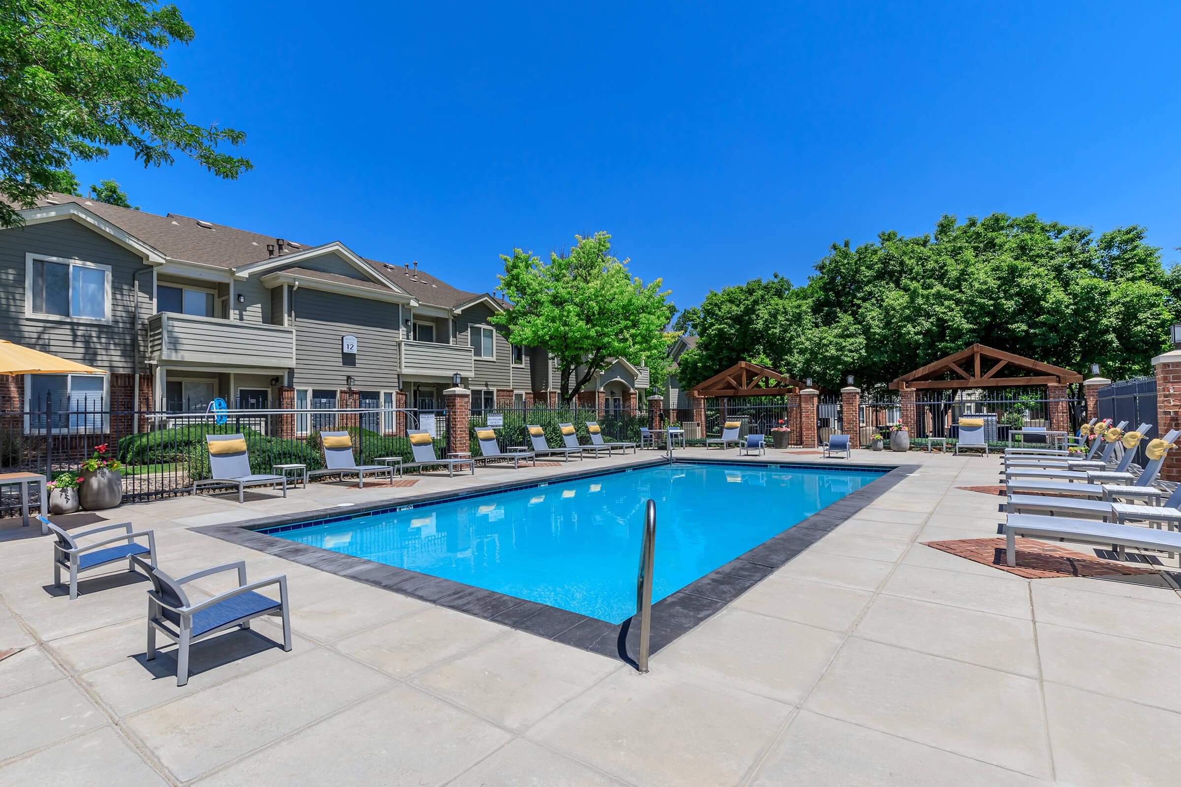 a group of lawn chairs sitting on top of a blue pool