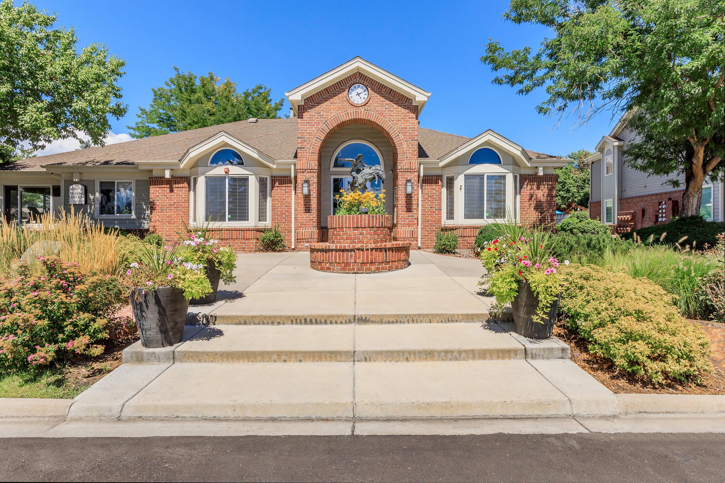 a large brick building with a clock on the side of a house