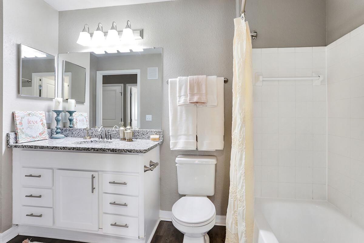 a white sink sitting under a mirror