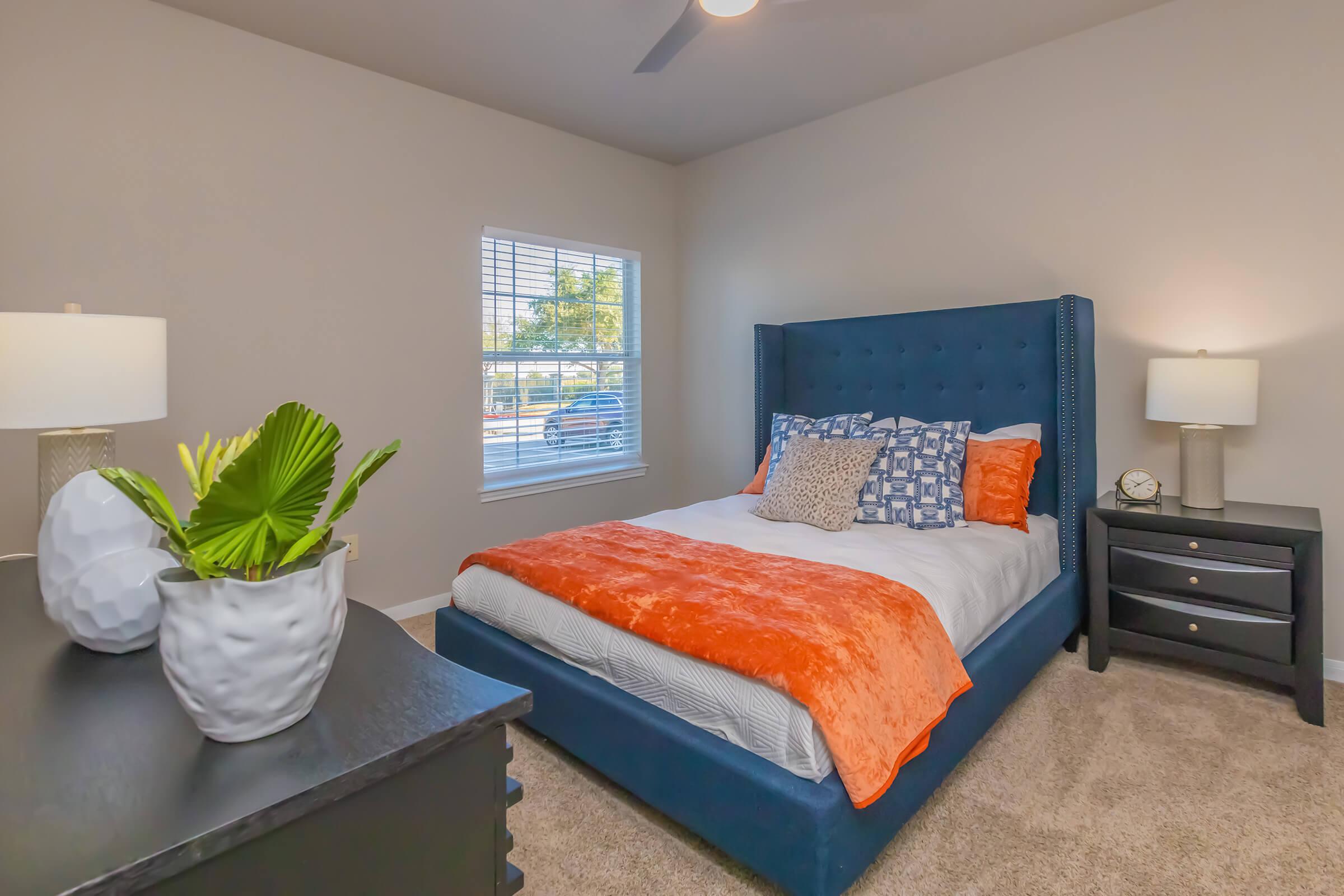 a bedroom with a bed and desk in a room