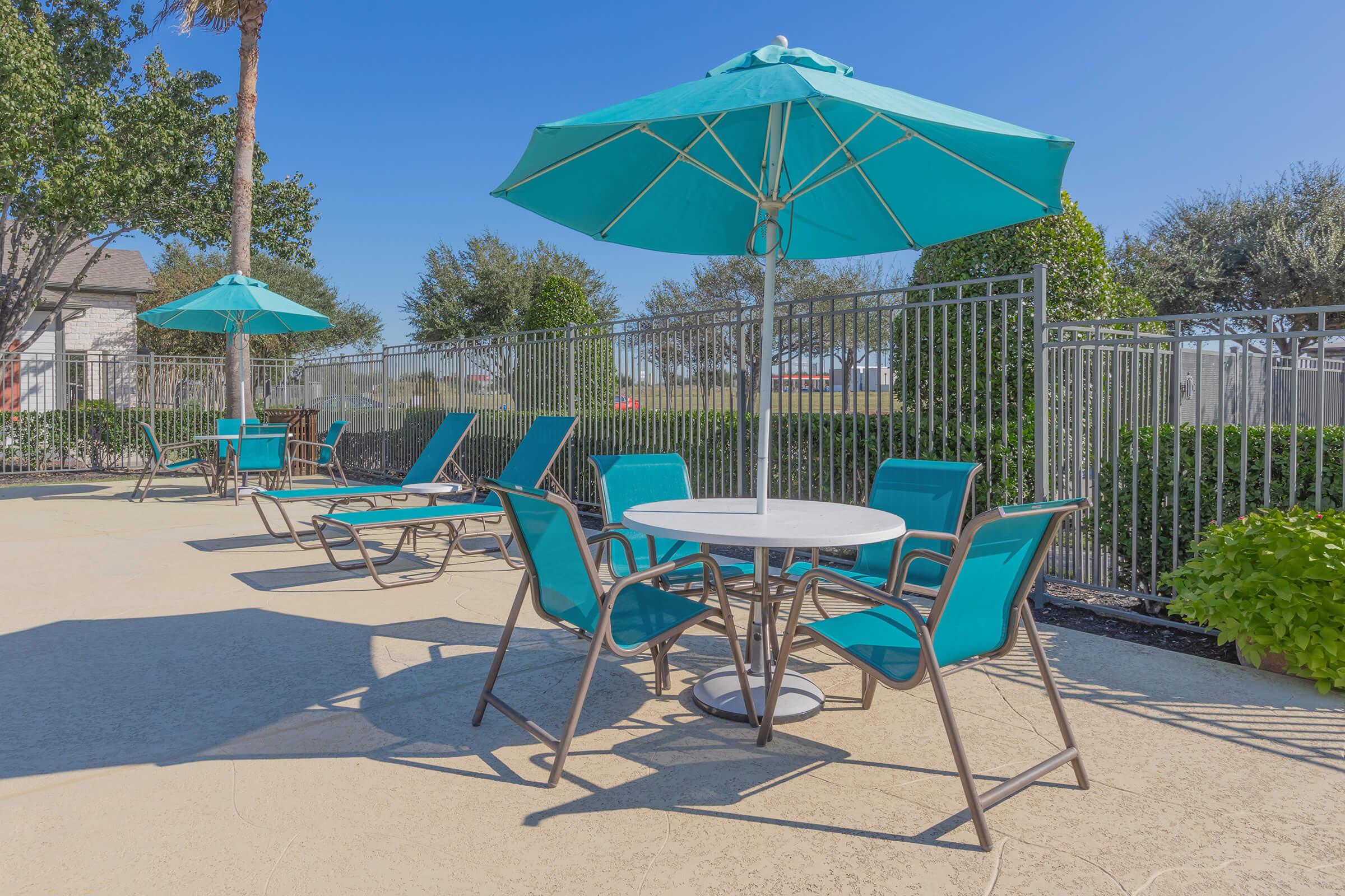 a group of lawn chairs sitting on top of a sandy beach