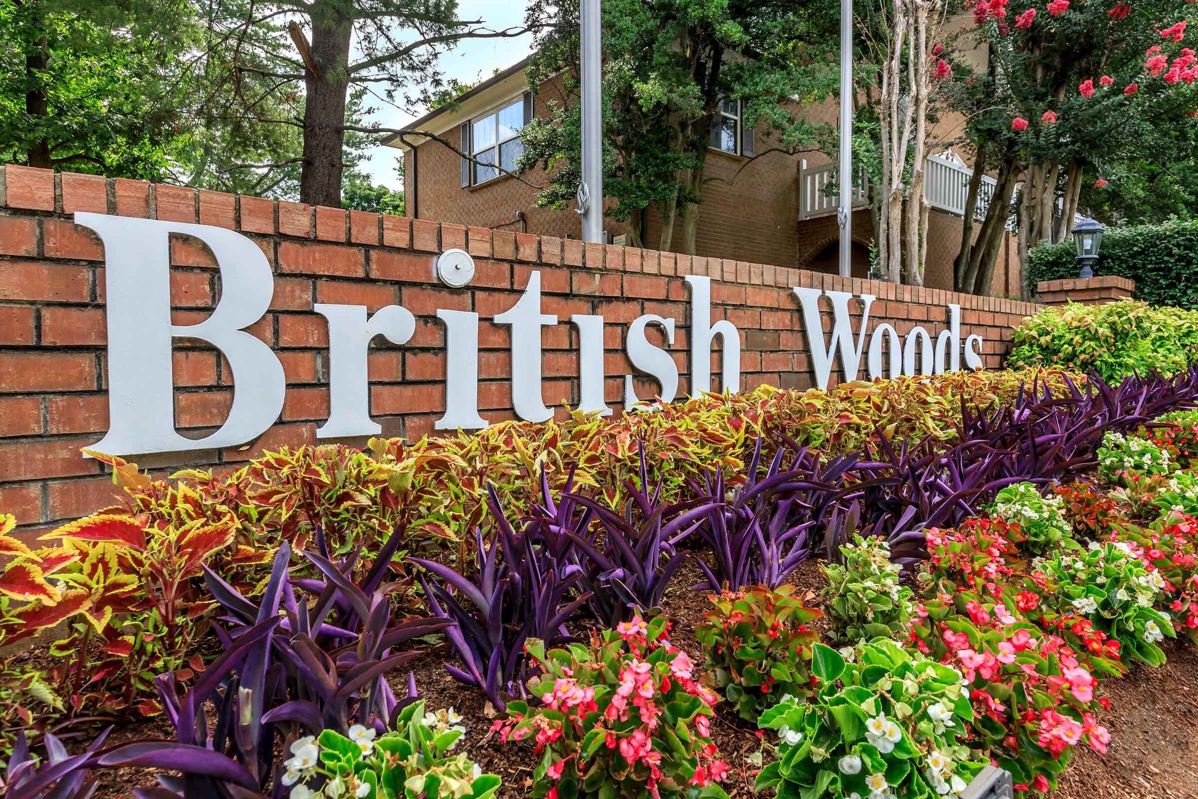 a close up of a flower garden in front of a brick building