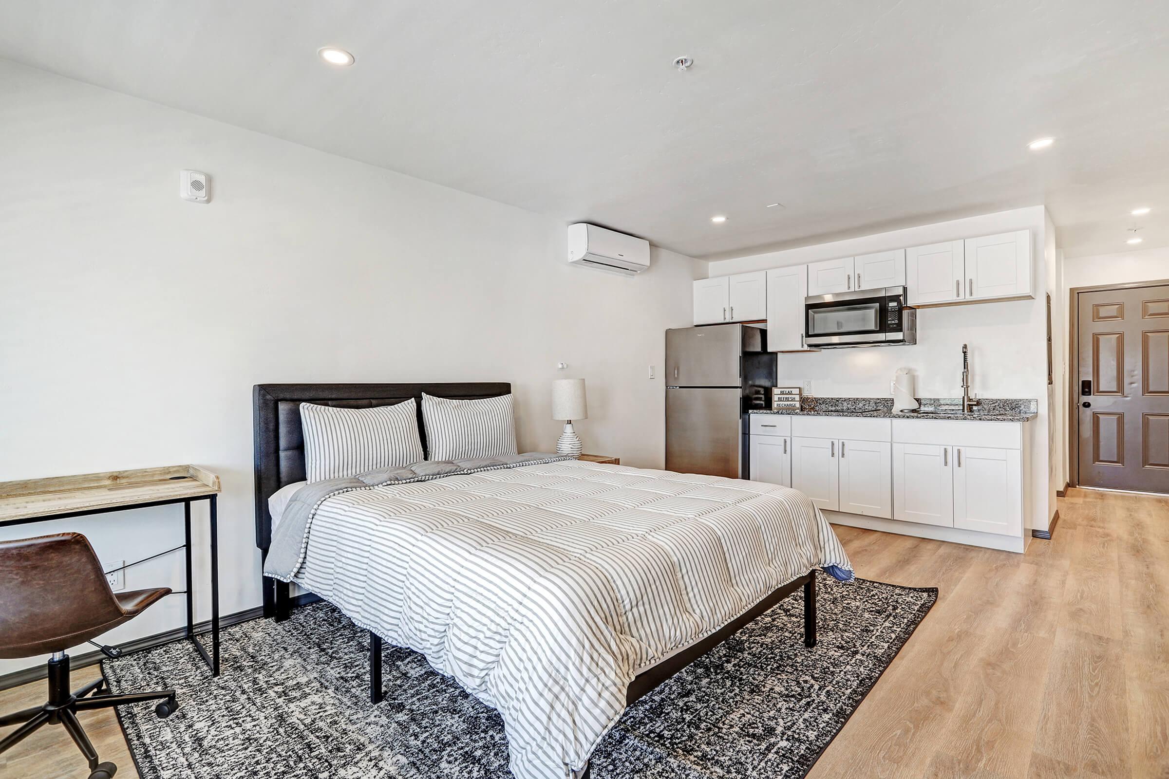 a bedroom with a bed and desk in a room