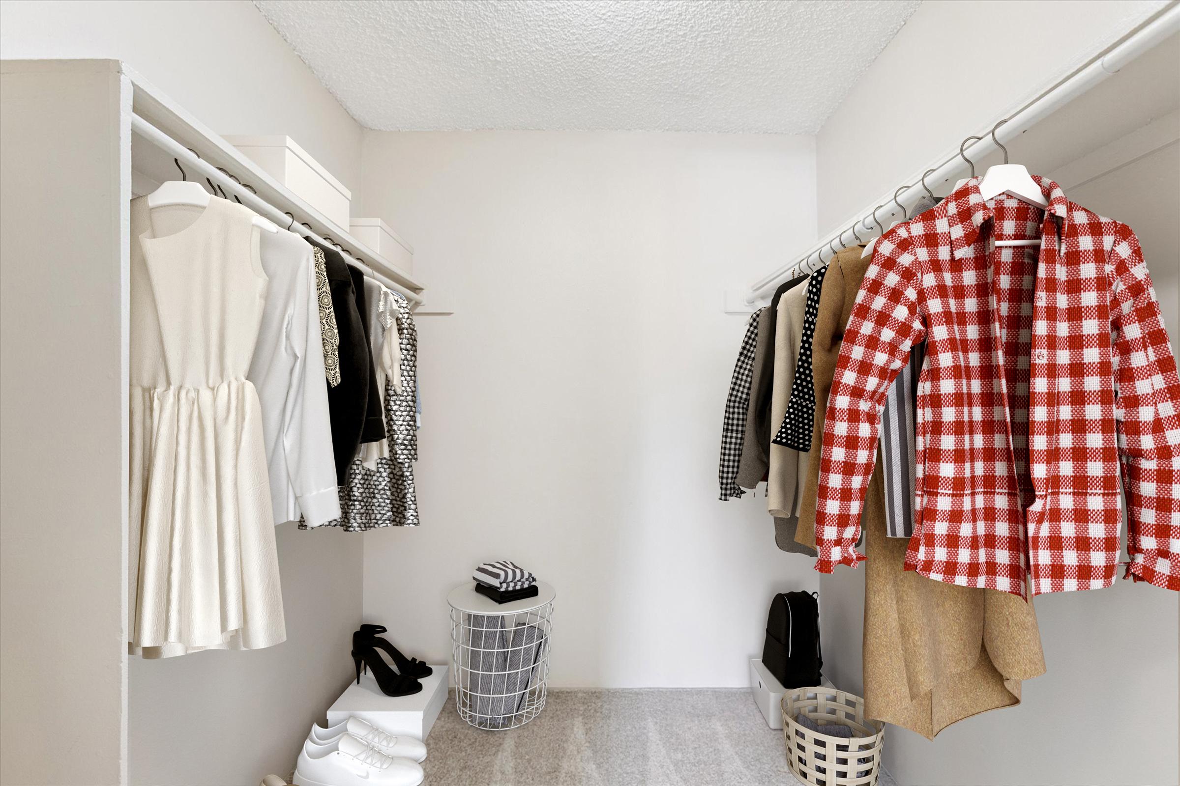 A neatly organized closet featuring a variety of clothing items. On the left, a light-colored dress hangs alongside other garments in neutral tones. On the right, a red checked shirt is displayed with beige shorts. At the bottom, shoes and storage baskets are visible, creating a clean and stylish arrangement.