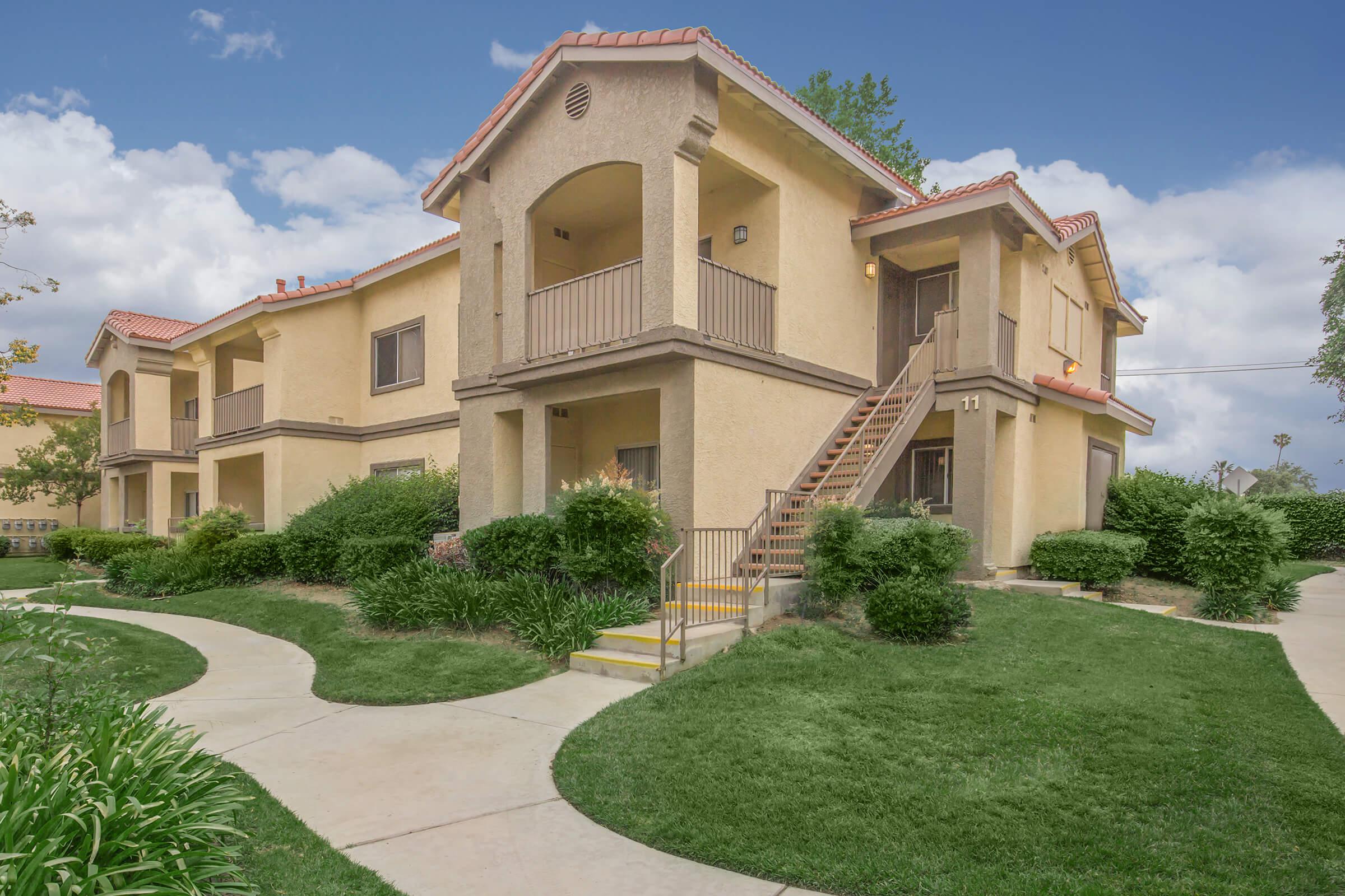 Club Pacifica Apartment Homes community building with green bushes