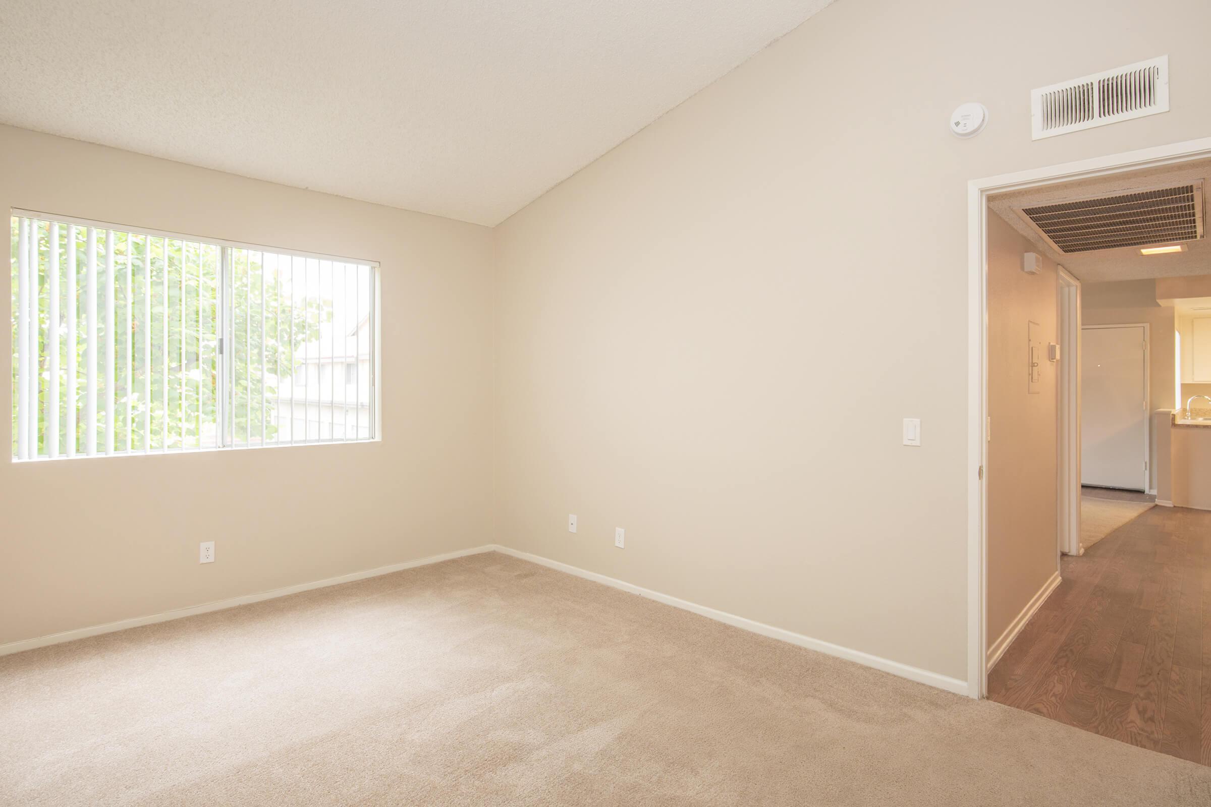 Carpeted bedroom with wooden floored hallway