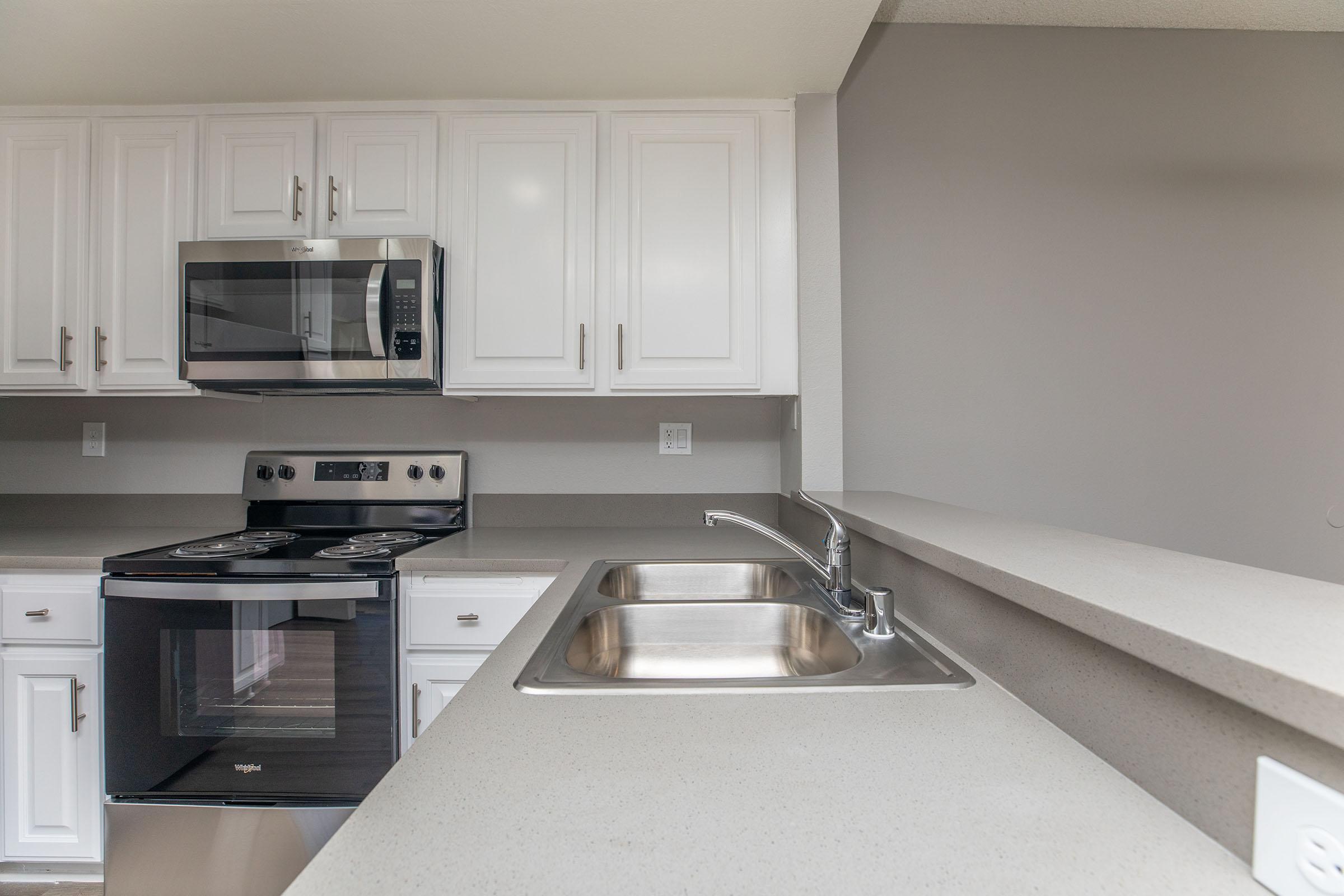 a kitchen with a stove a sink and a microwave