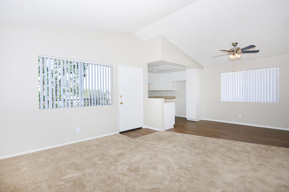 Carpeted living room and dining room with wooden floors