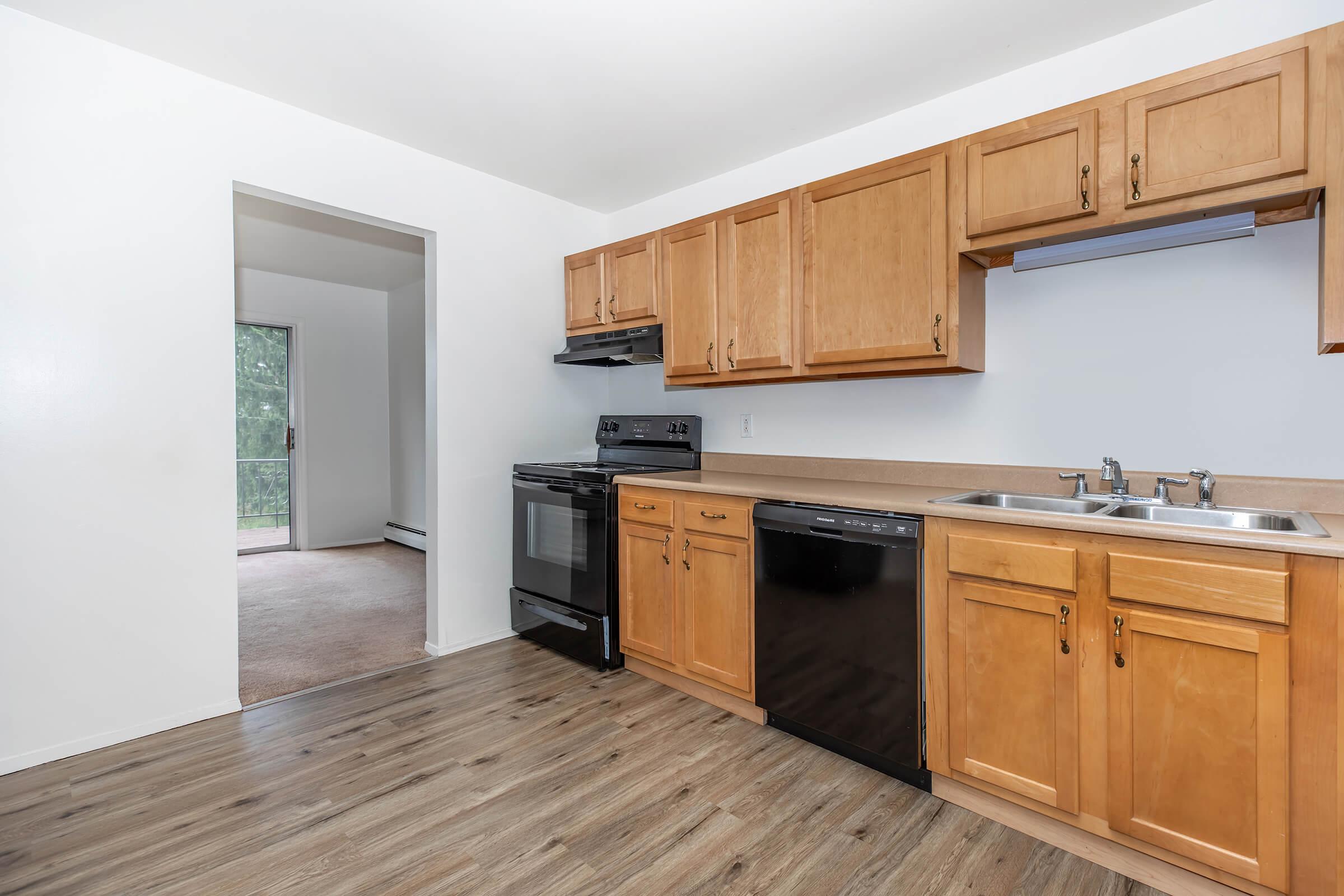 a kitchen with wooden cabinets and a wood floor