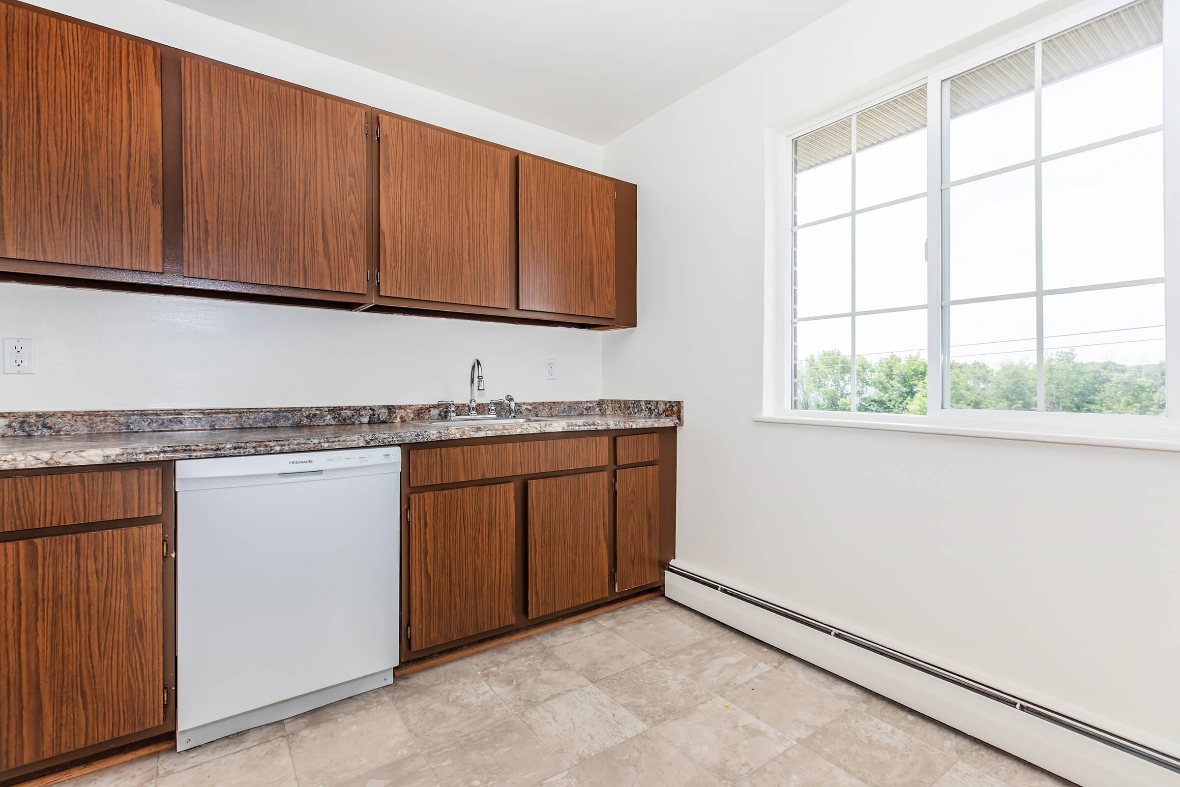 a kitchen with wooden cabinets and a window