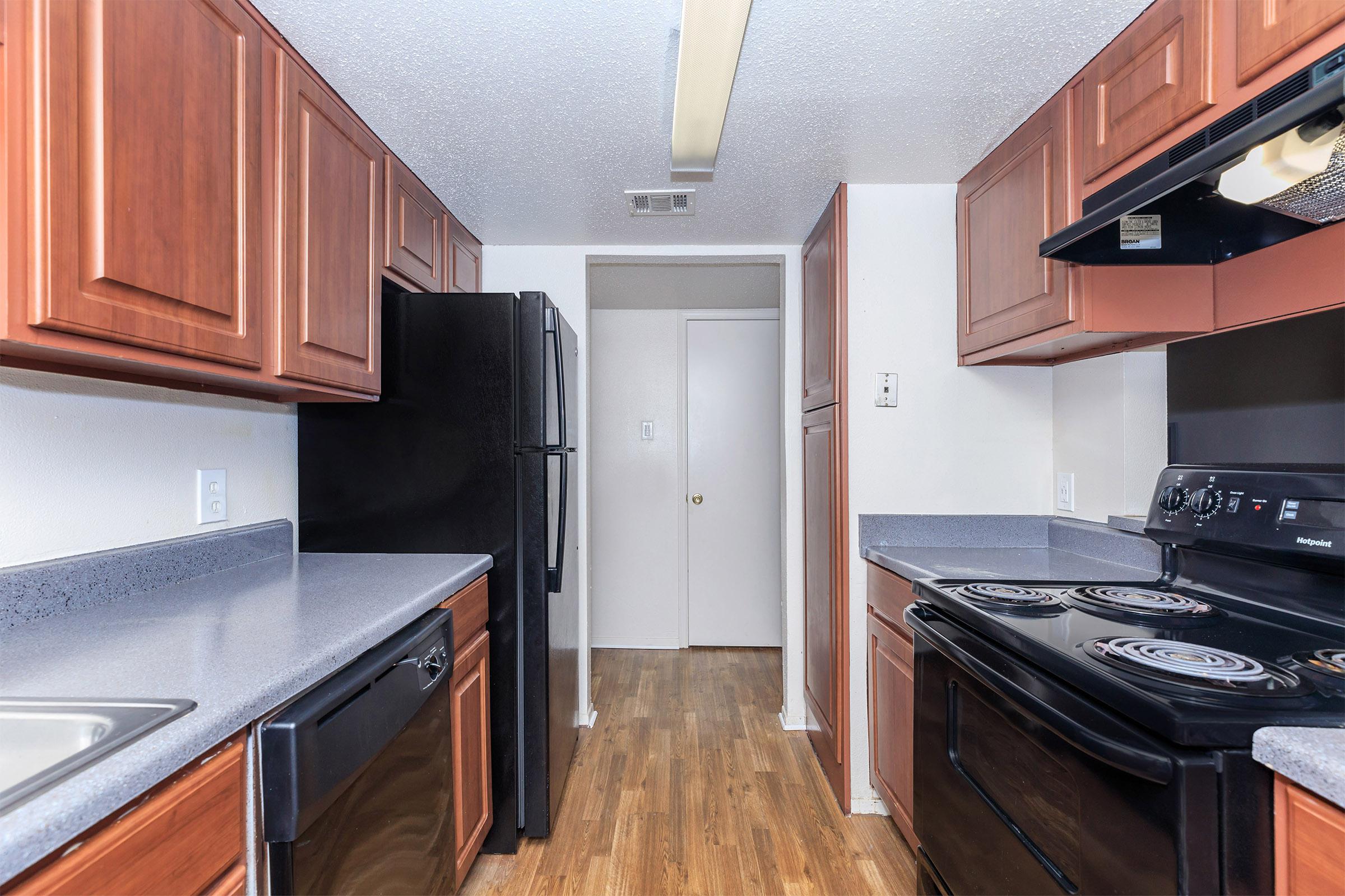 a modern kitchen with stainless steel appliances and wooden cabinets