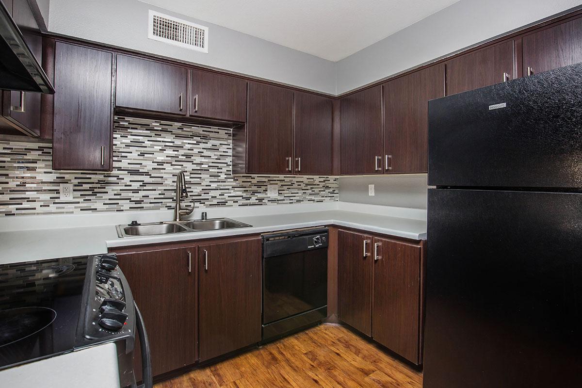 a large kitchen with stainless steel appliances and wooden cabinets