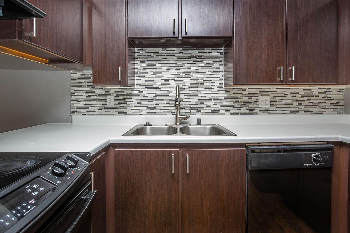 a kitchen with wooden cabinets and a black stove top oven