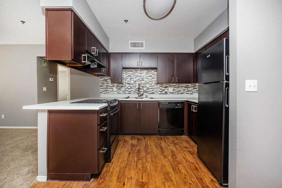 a large kitchen with stainless steel appliances and wooden cabinets