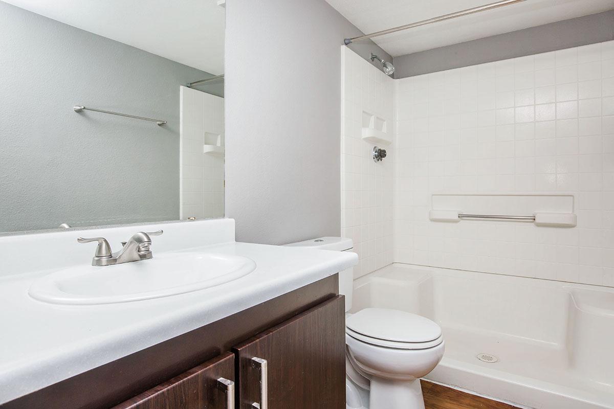 a white sink sitting under a mirror