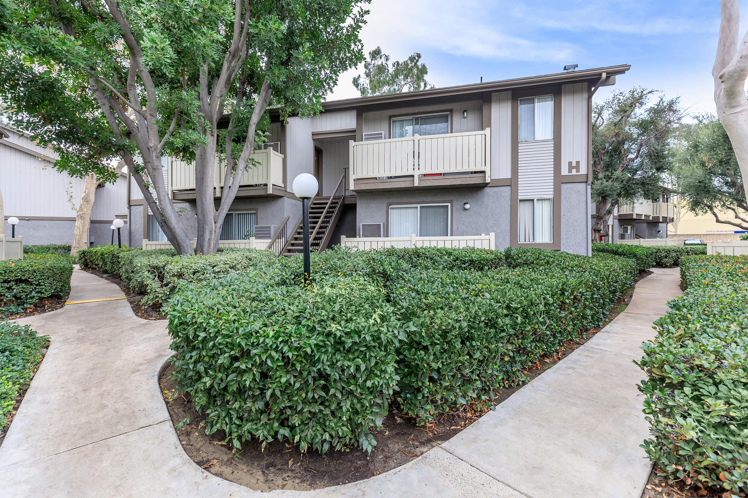 Monte Verde Apartment Homes community building with green shrubs