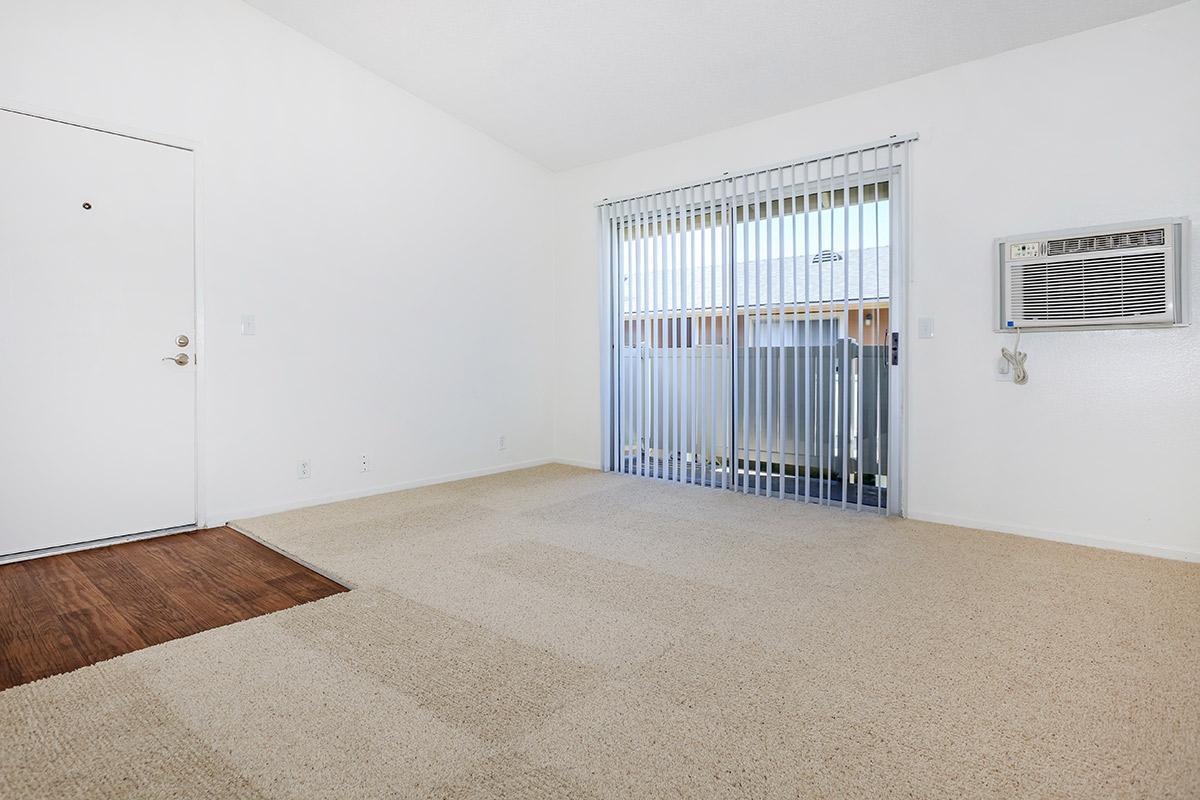 Unfurnished carpeted living room with sliding glass doors