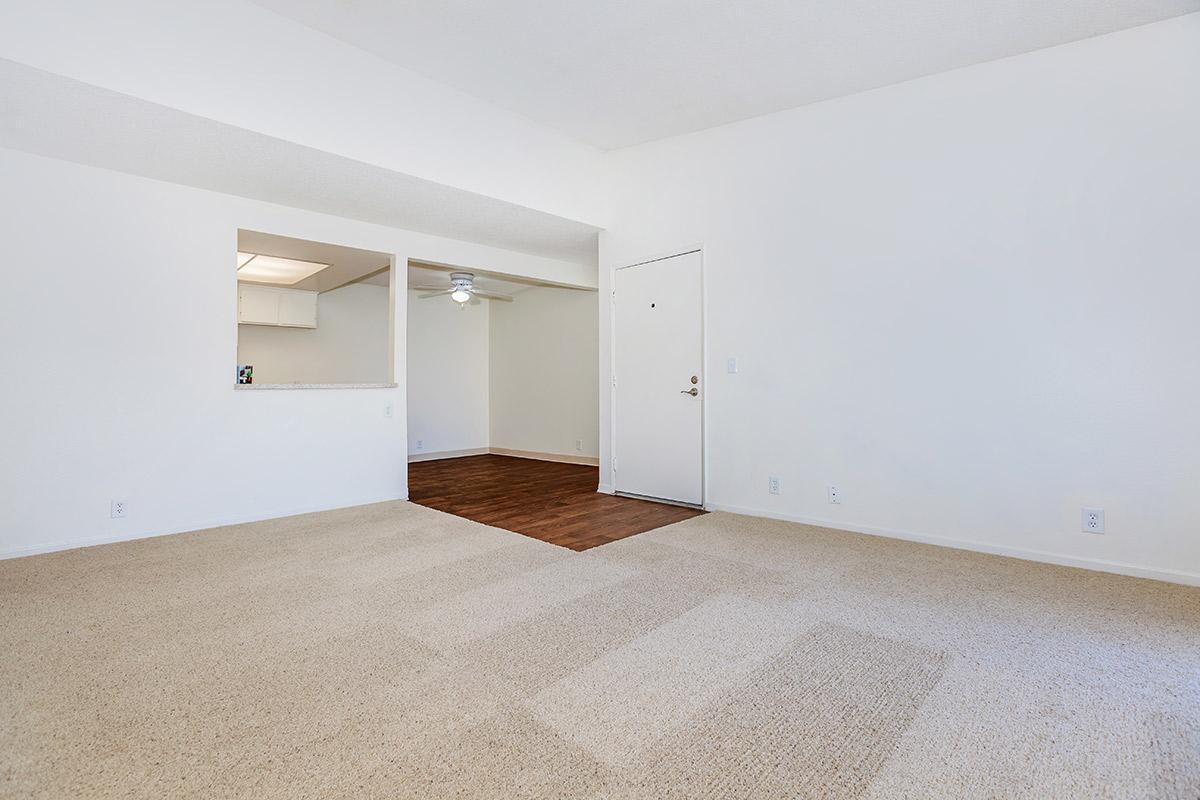 Dining room with wooden floors and carpeted living room