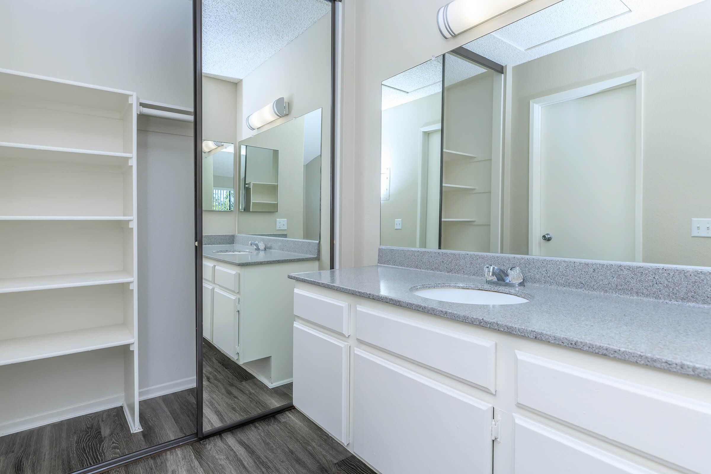 Bathroom sink with open sliding mirror glass closet door