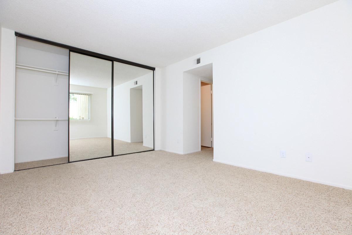 Unfurnished bedroom with sliding mirror glass closet doors