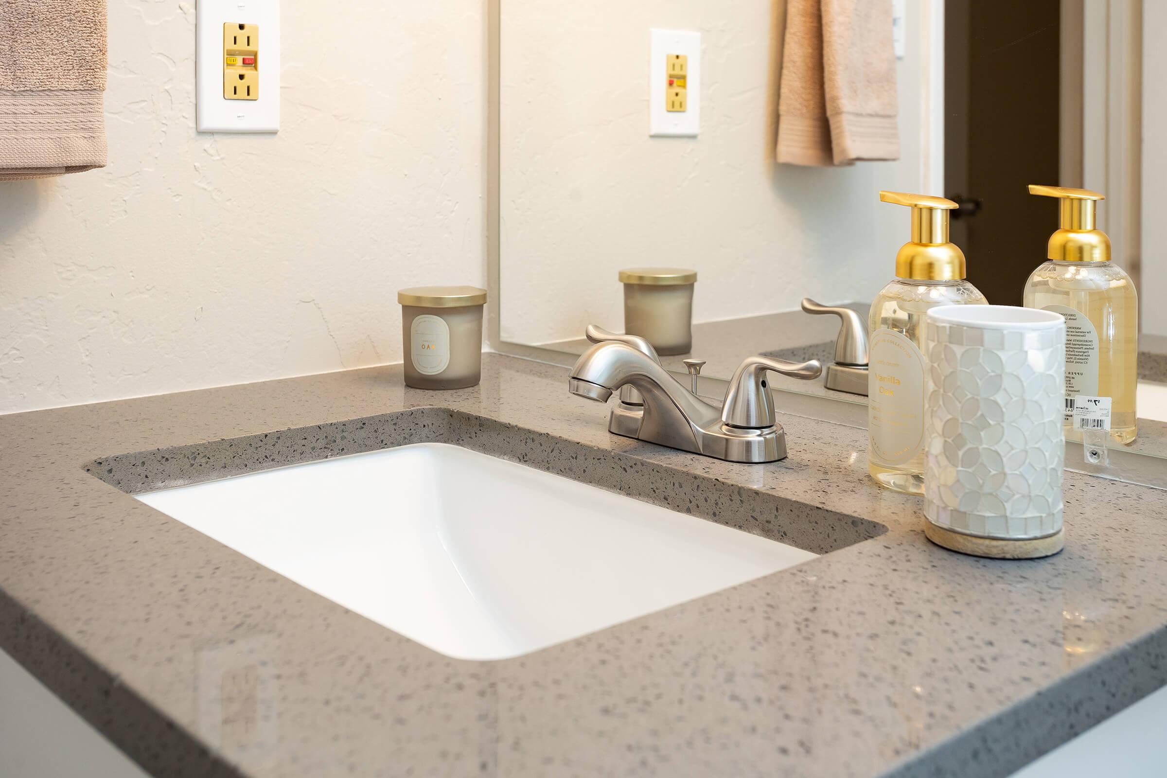 a counter with a sink and a mirror