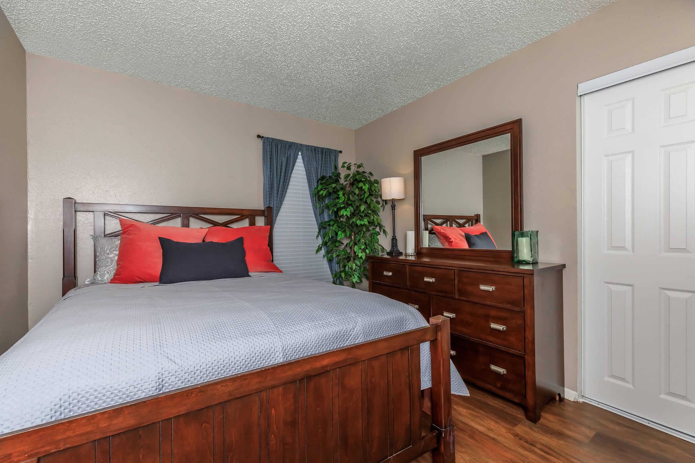 a bedroom with a bed and desk in a room