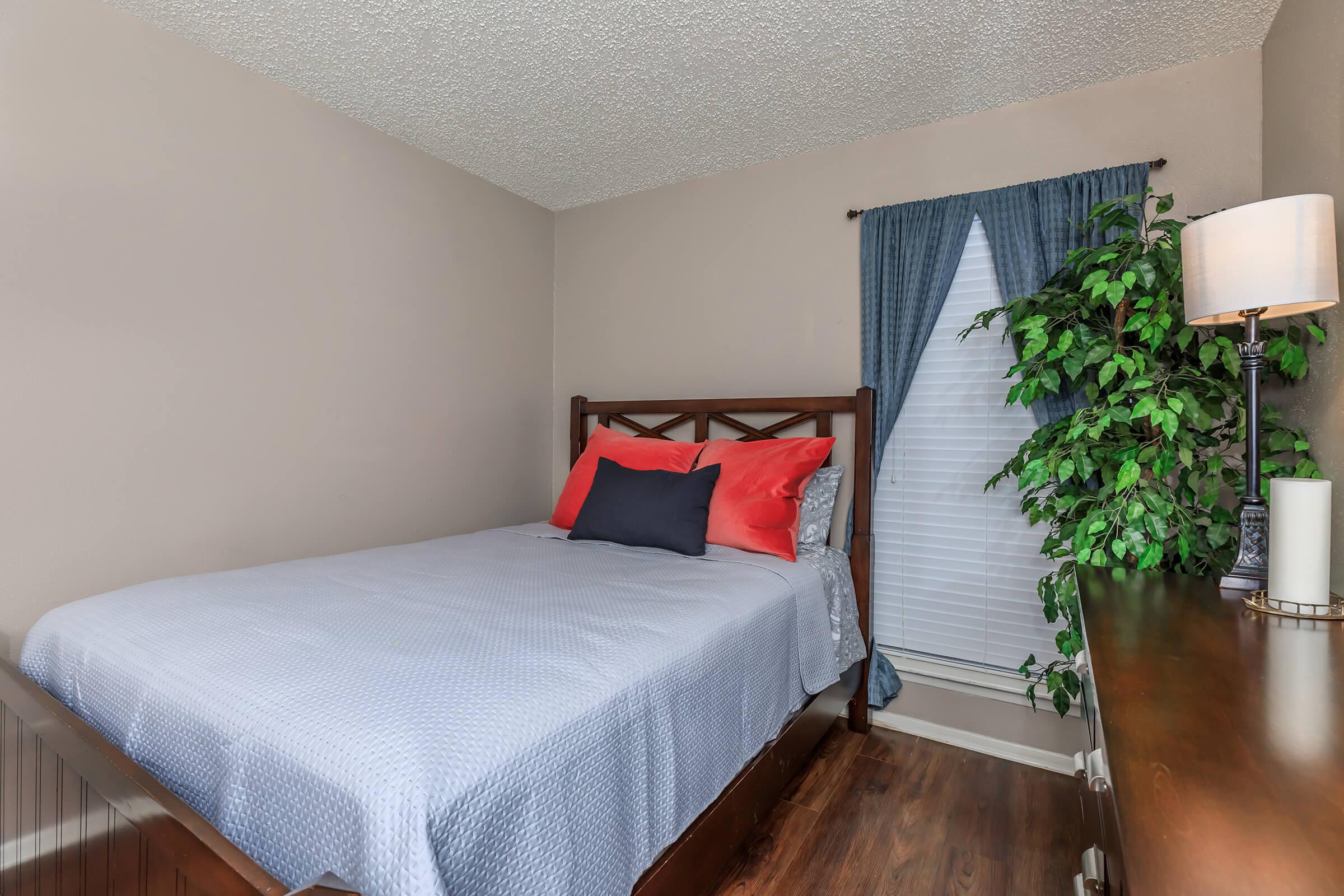 a bedroom with a bed and desk in a room