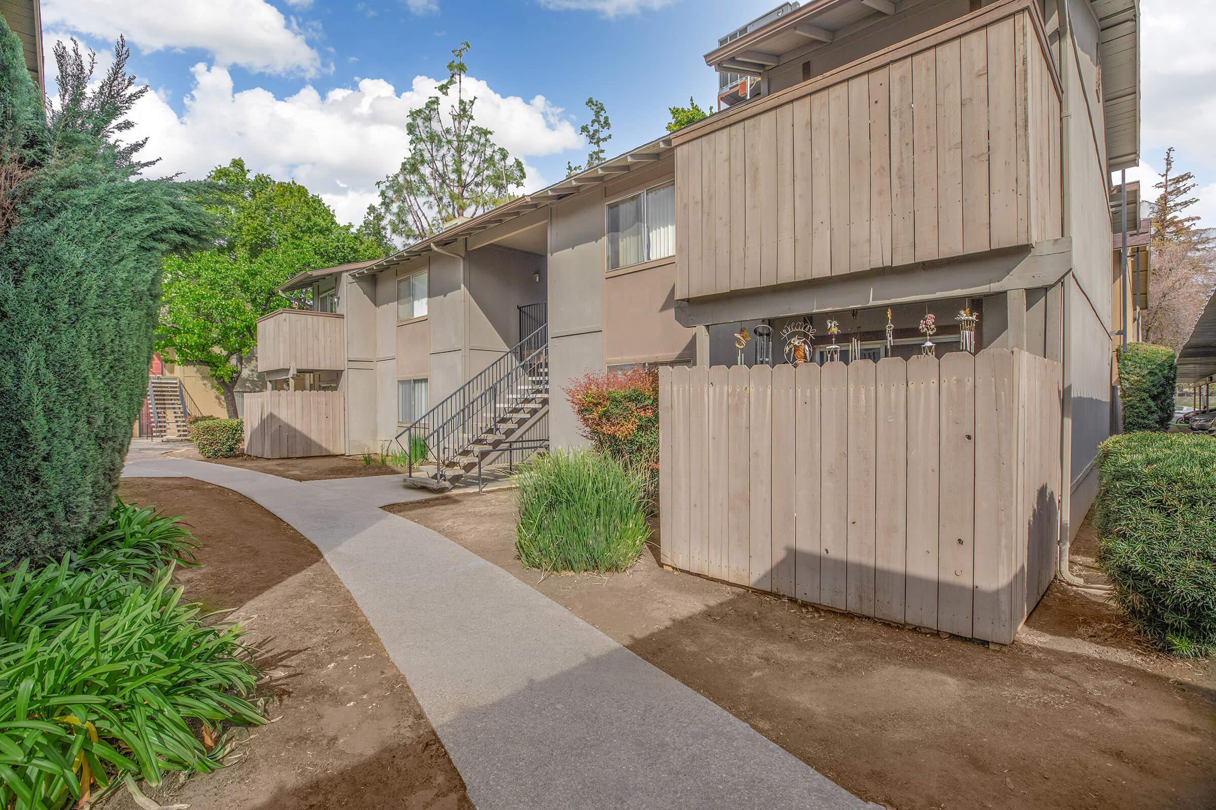 a path with trees on the side of a building