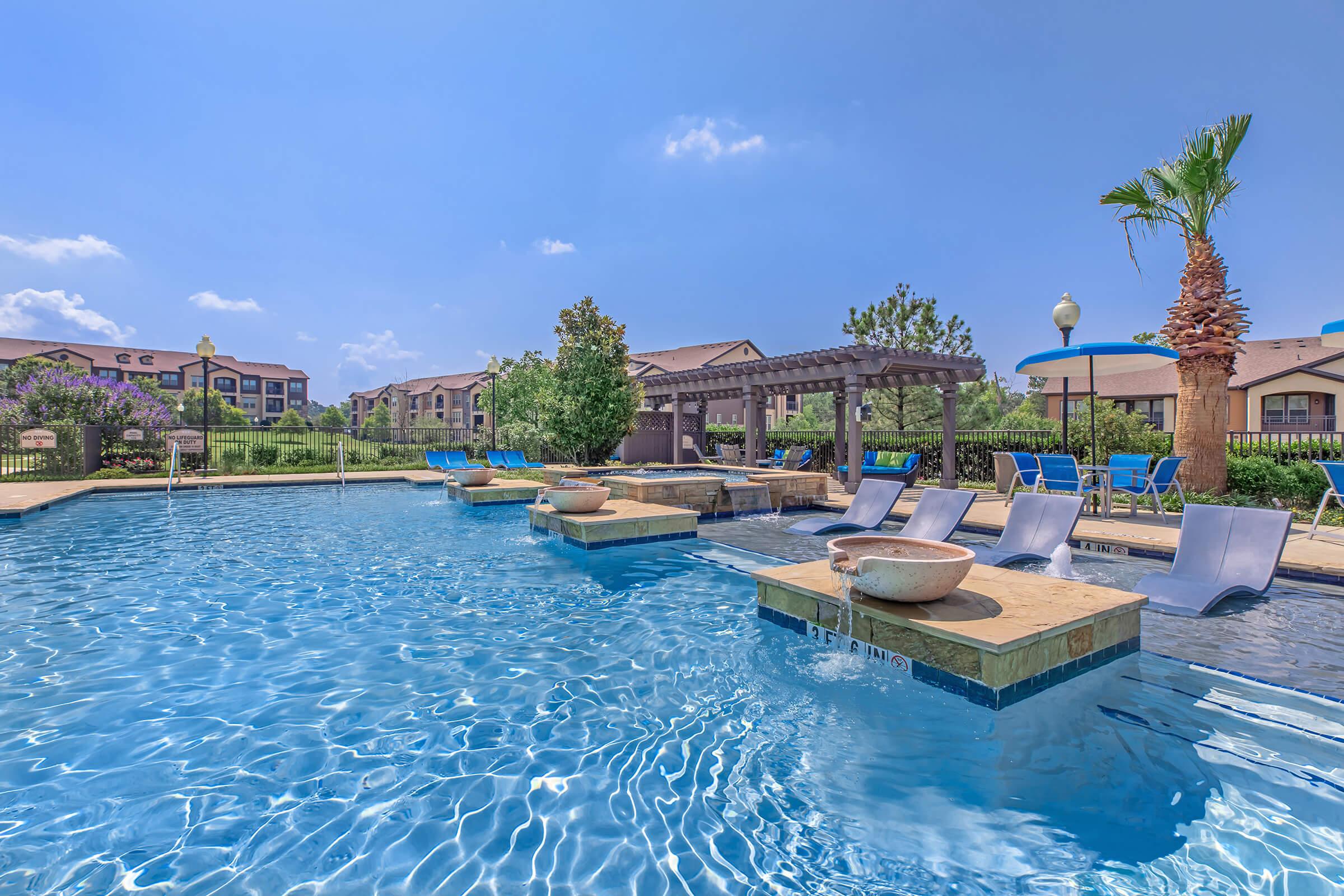 a group of lawn chairs sitting next to a pool of water