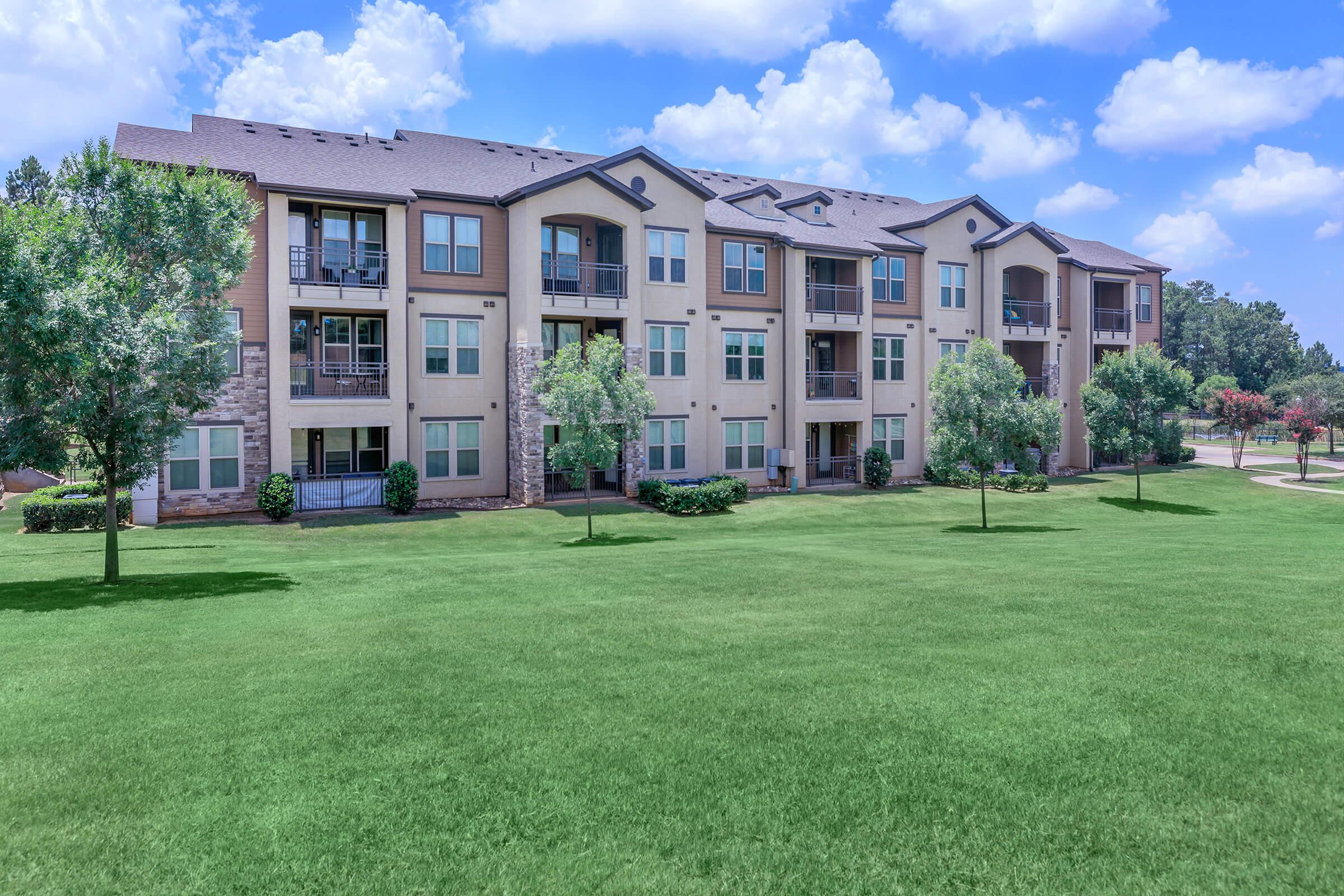 Paladin Apartments community building with green grass