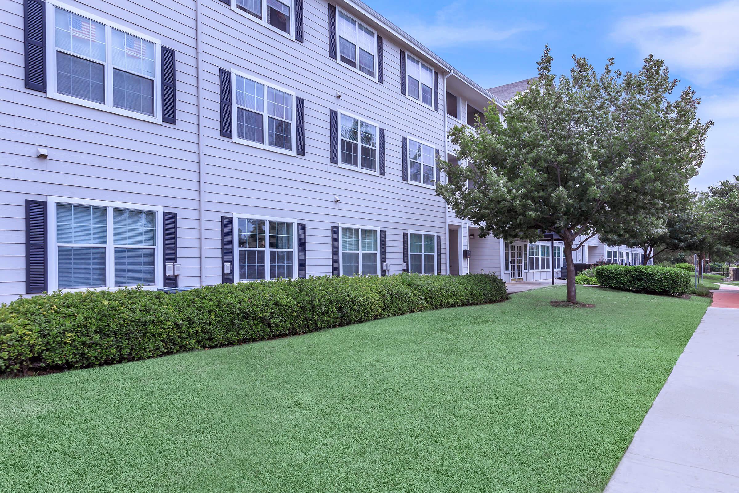 a large lawn in front of a brick building