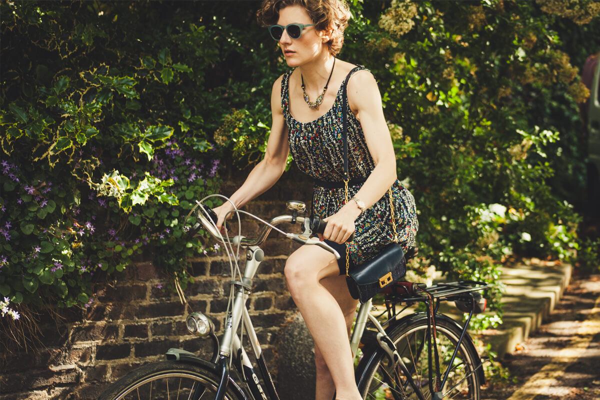 a woman riding on the back of a bicycle