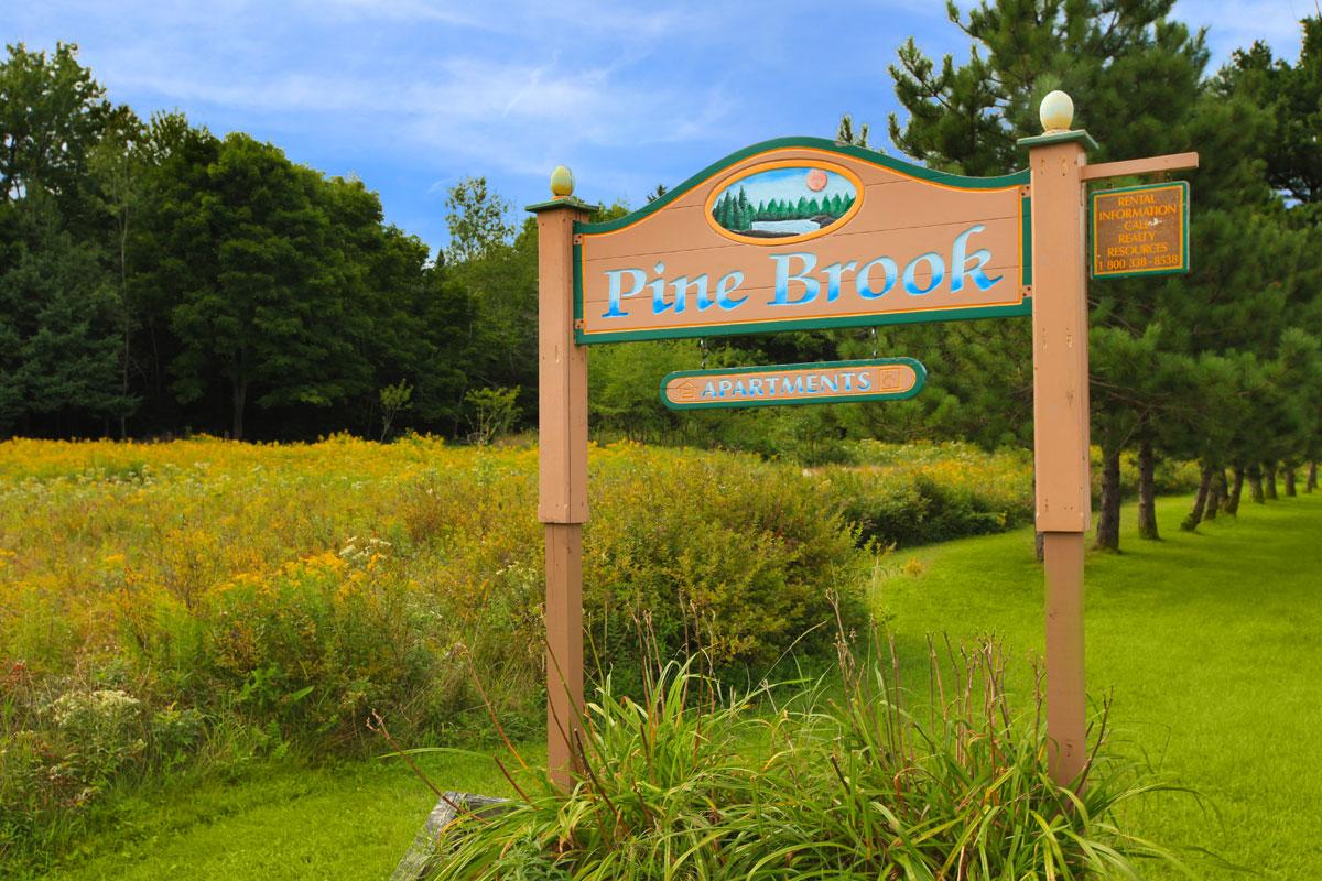 a sign on the side of a lush green field