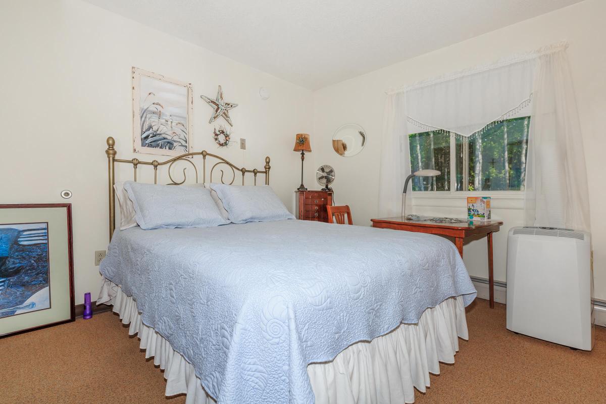 a bedroom with a bed and desk in a room