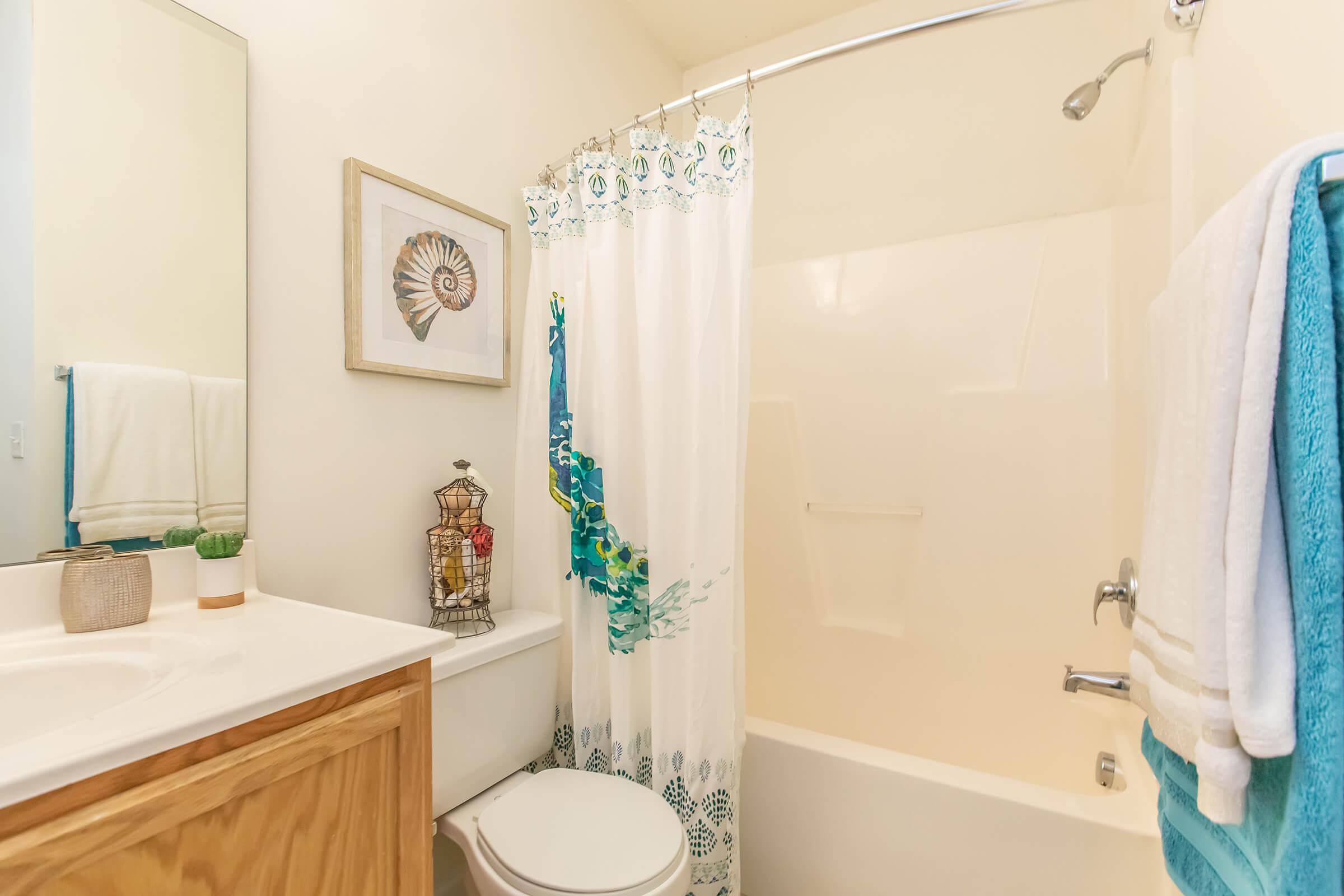 a white tub sitting next to a shower curtain