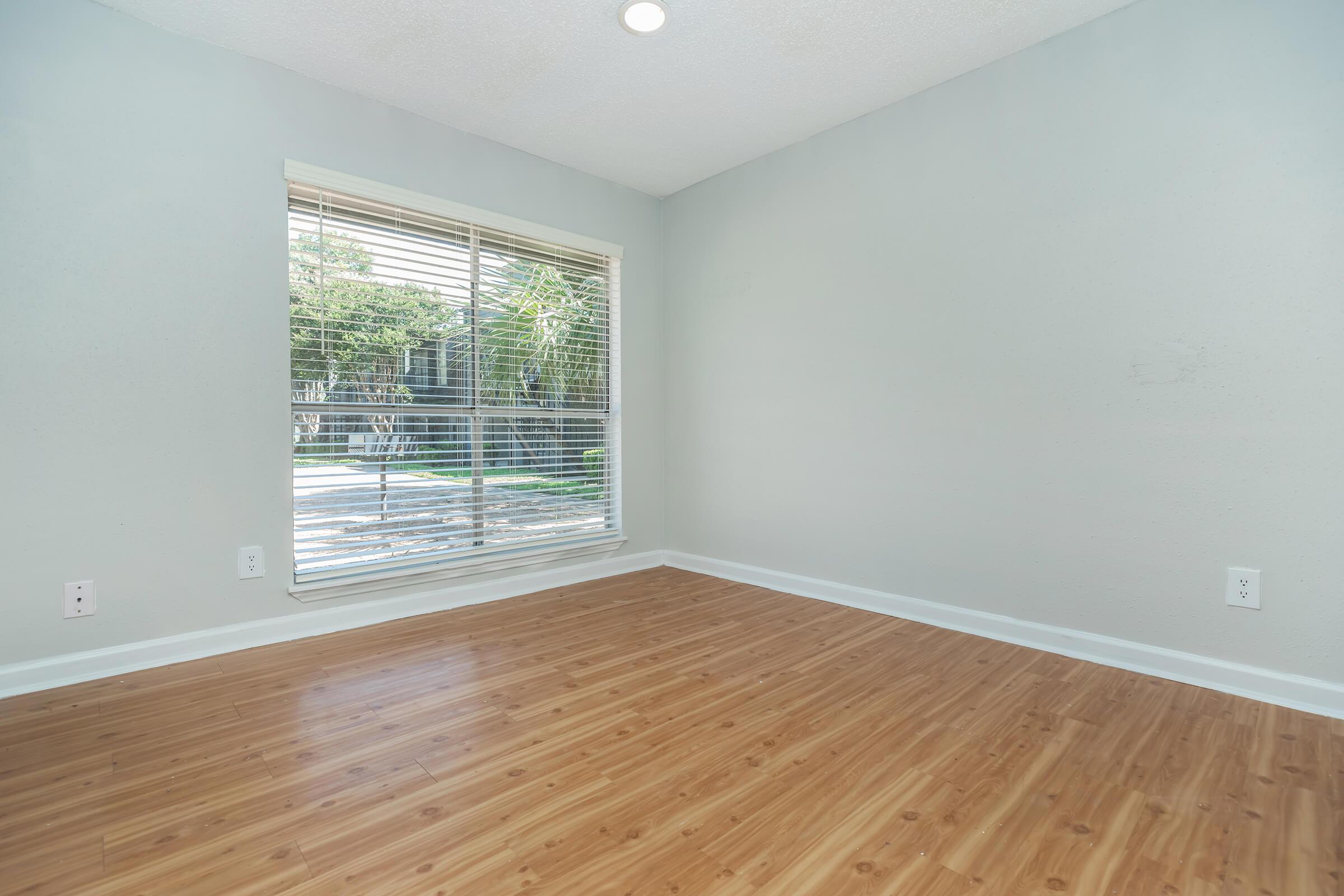 a close up of a hard wood floor next to a window