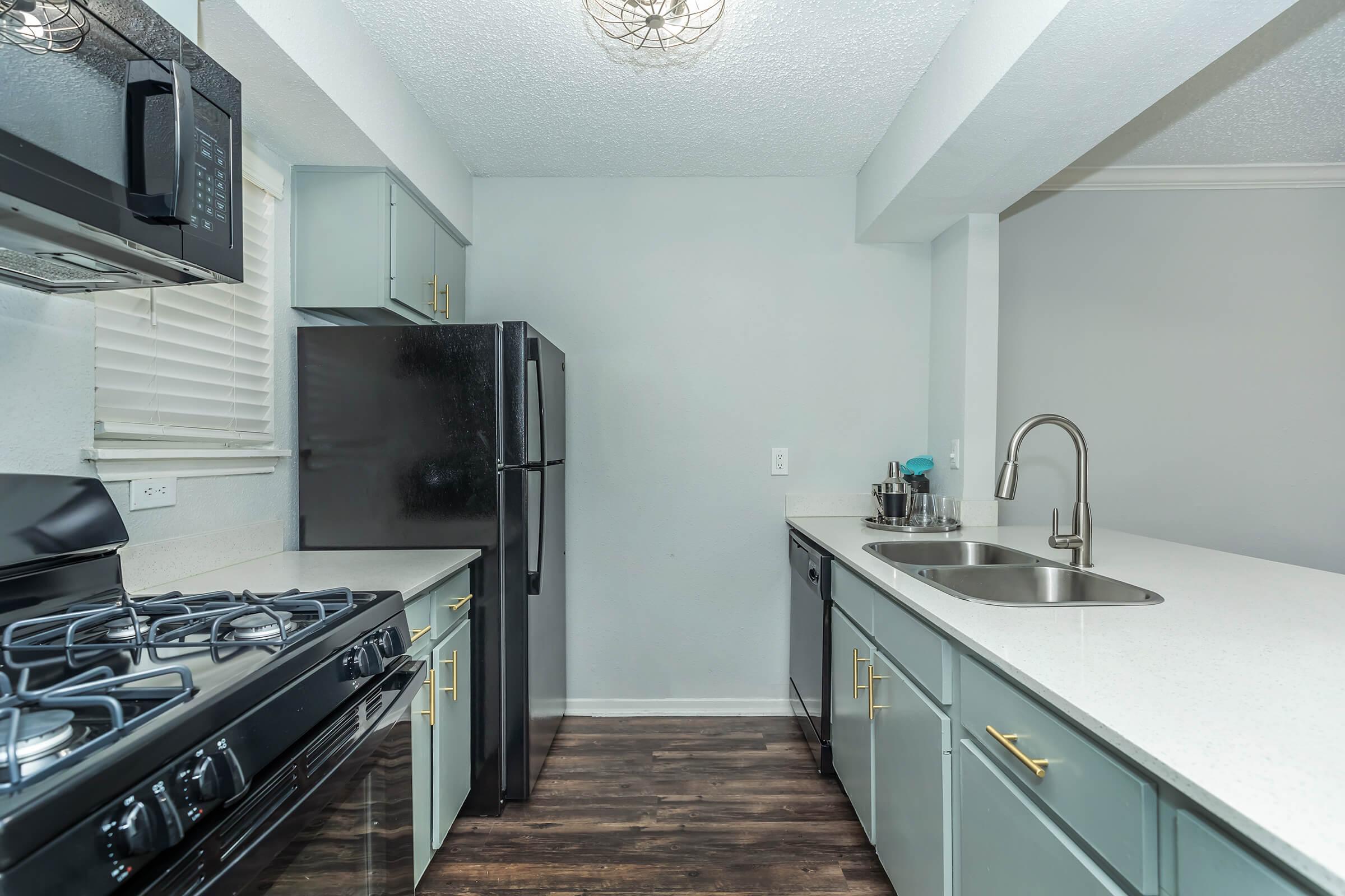 a stove top oven sitting inside of a kitchen with stainless steel appliances