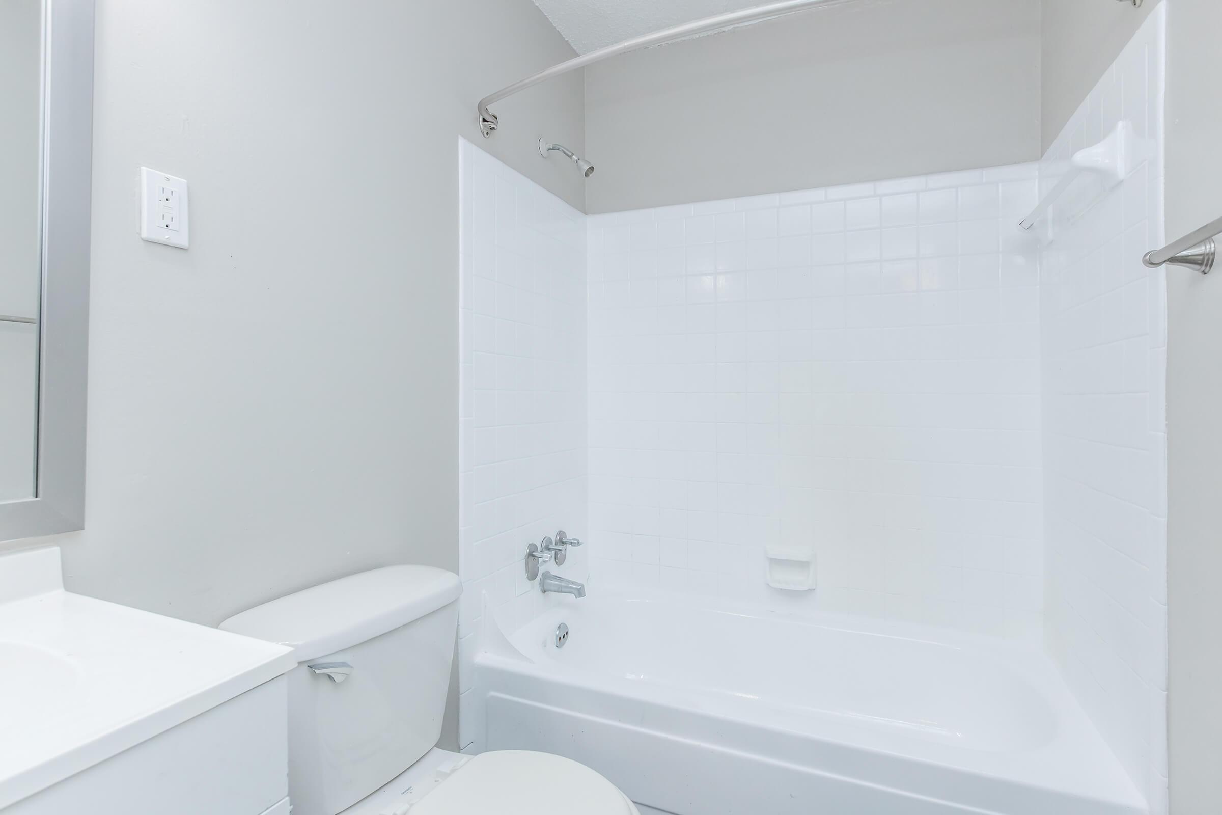a room with a sink and a white tub sitting next to a shower
