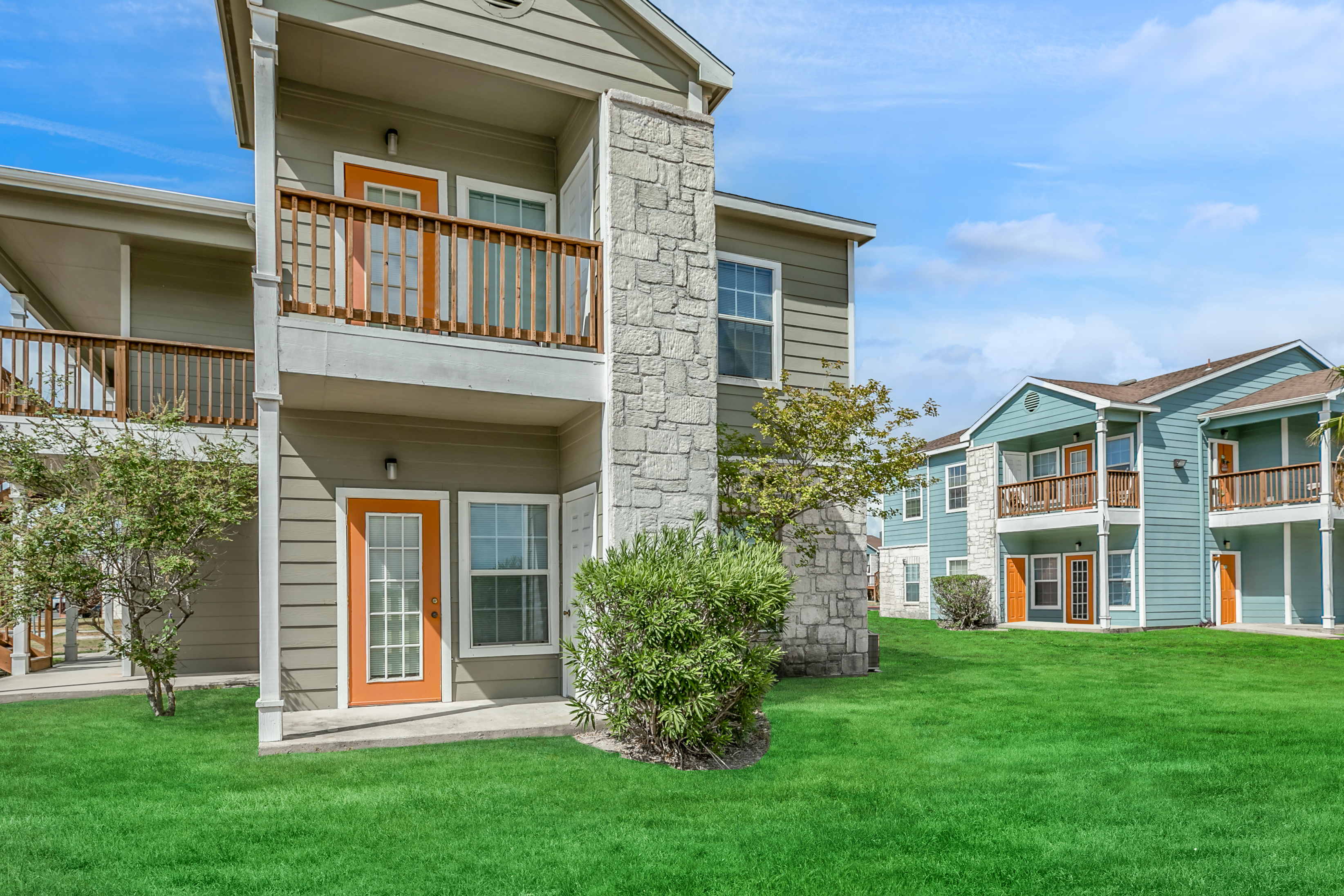 Exterior building 2 stories with view of patio open greenspace and balconies  Portside Villas Apts