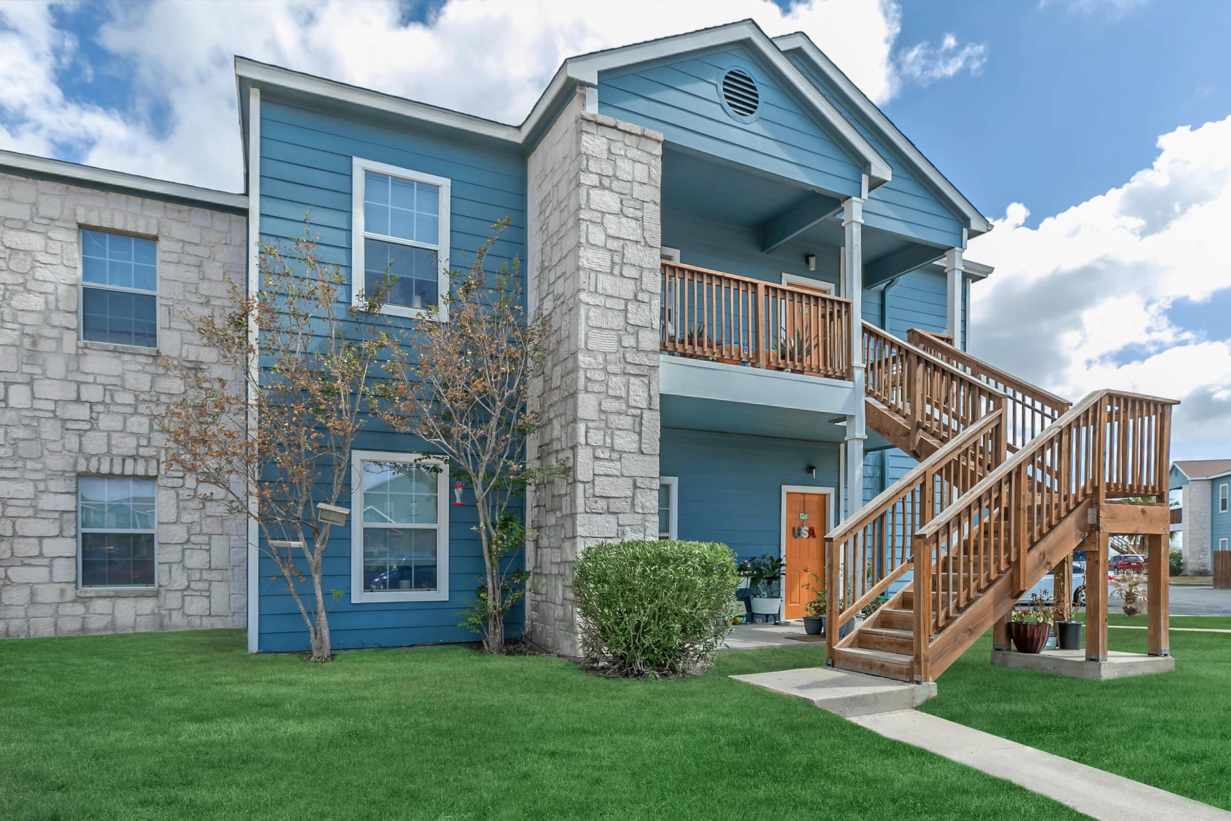 Exterior building 2 stories with view of patio open greenspace and balconies  Portside Villas Apts