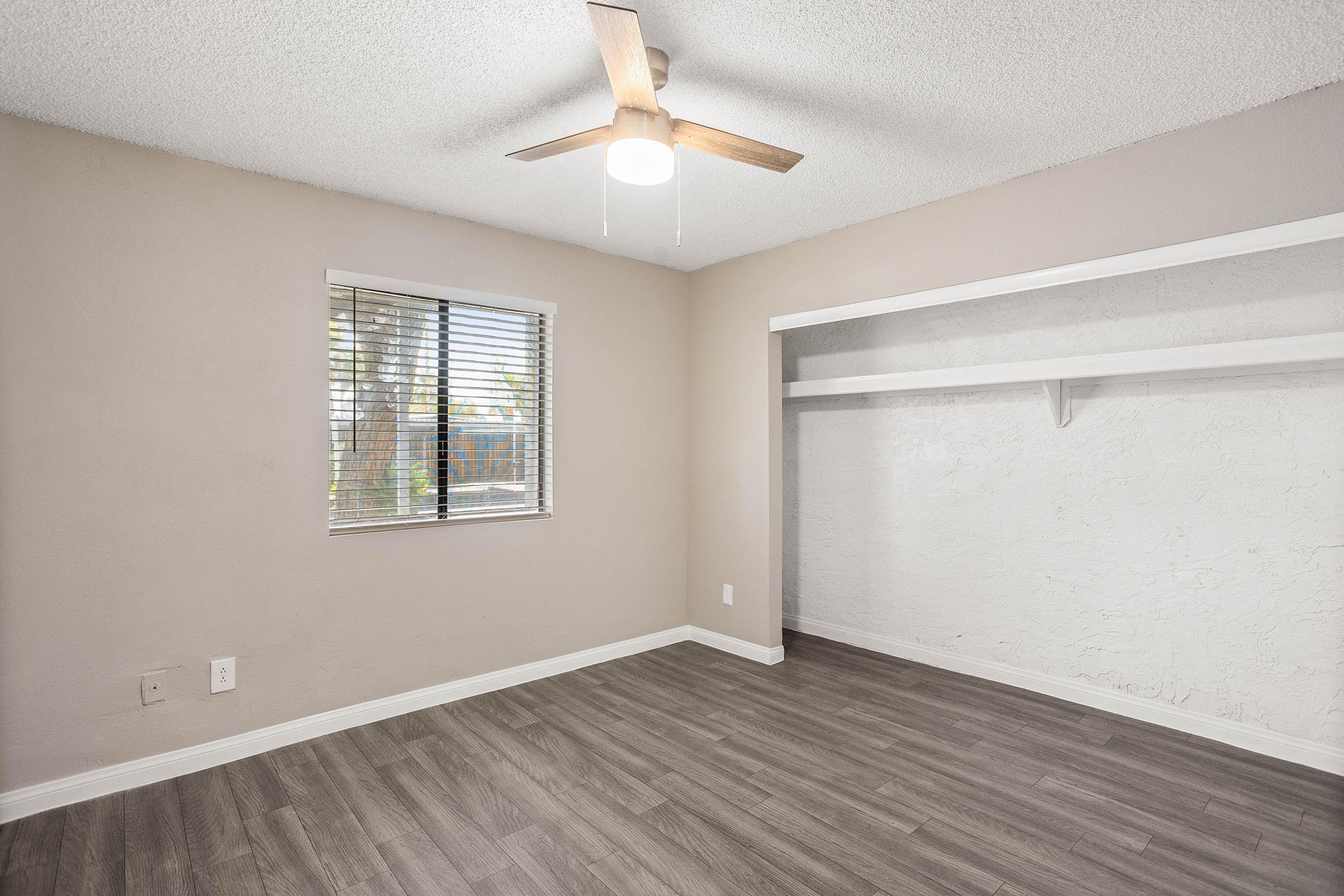 Large spacious bedroom with window, ceiling fan, and built in closet space.