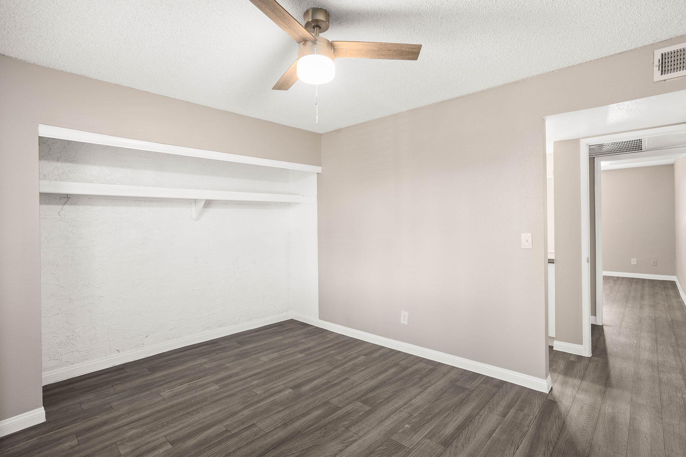 Large bedroom with ceiling fan, built in closet, and vinyl plank flooring