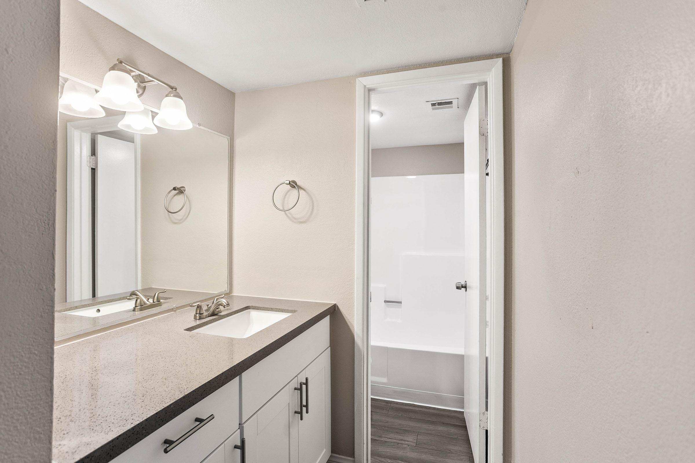 renovated bathroom with quartz countertops and separate shower and toilet room