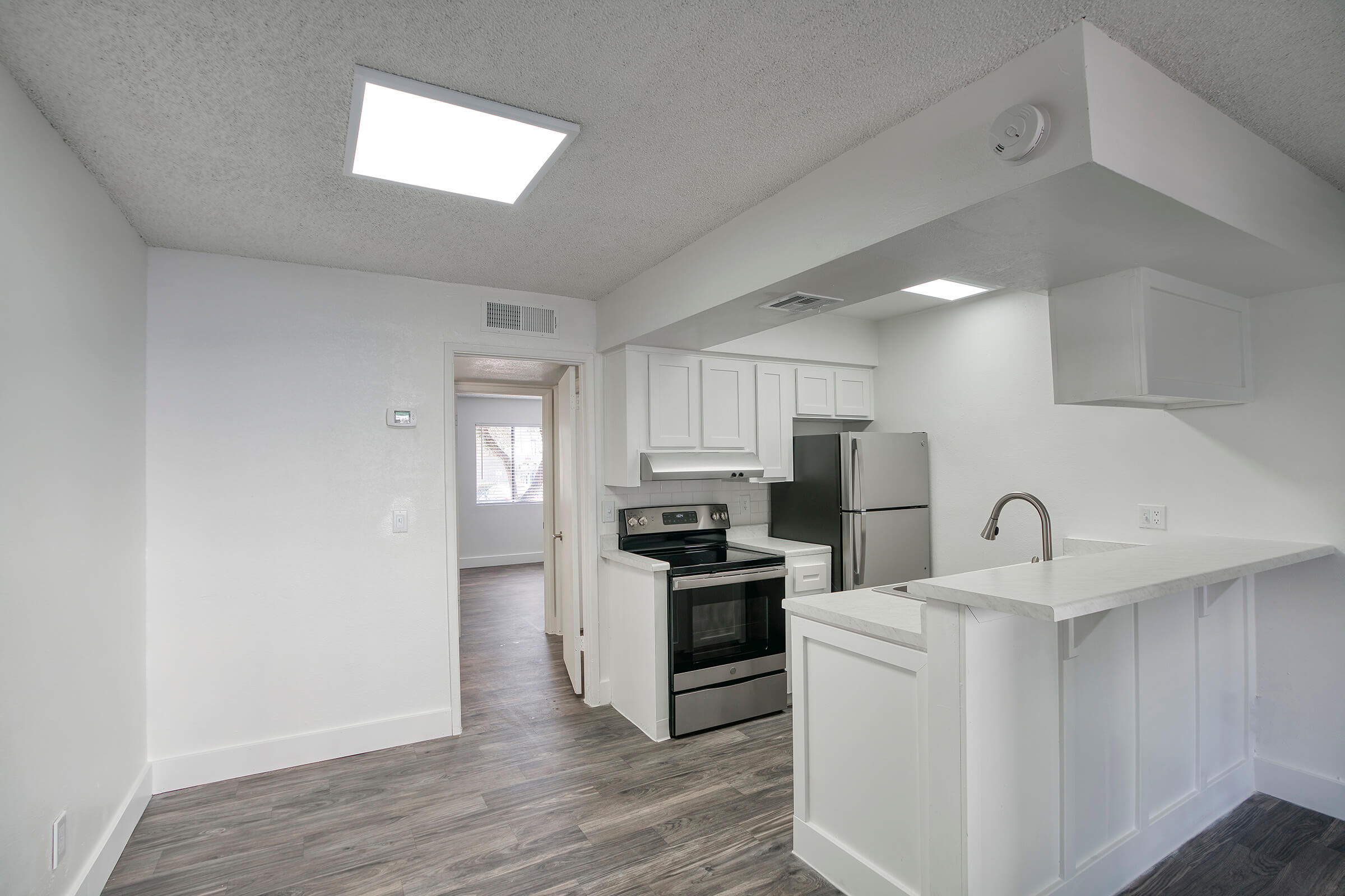 Renovated kitchen with white cabinets, stainless steel appliances, and a walk up kitchen island