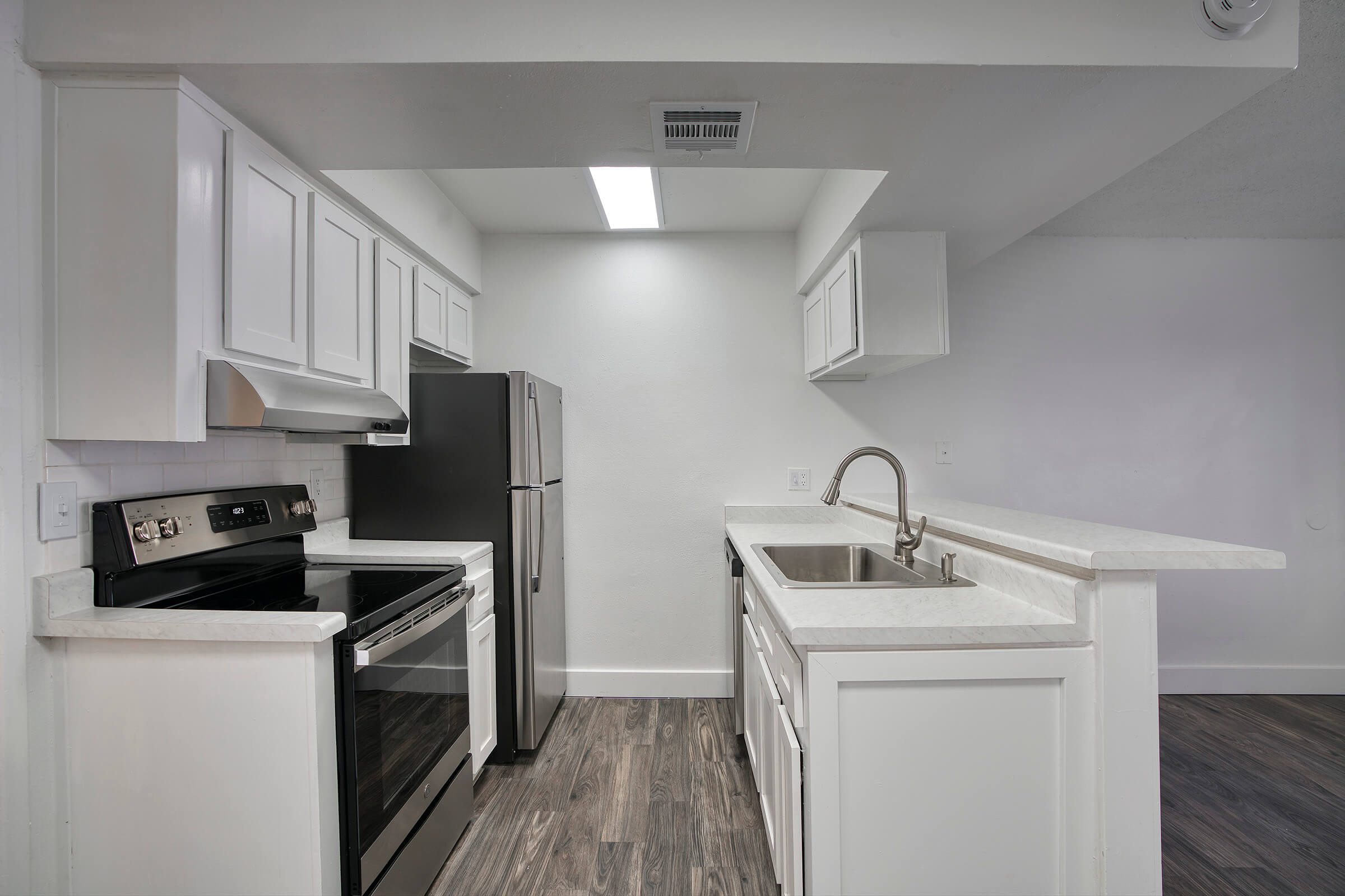 Renovated kitchen with white cabinets, stainless steel appliances, and a walk up kitchen island