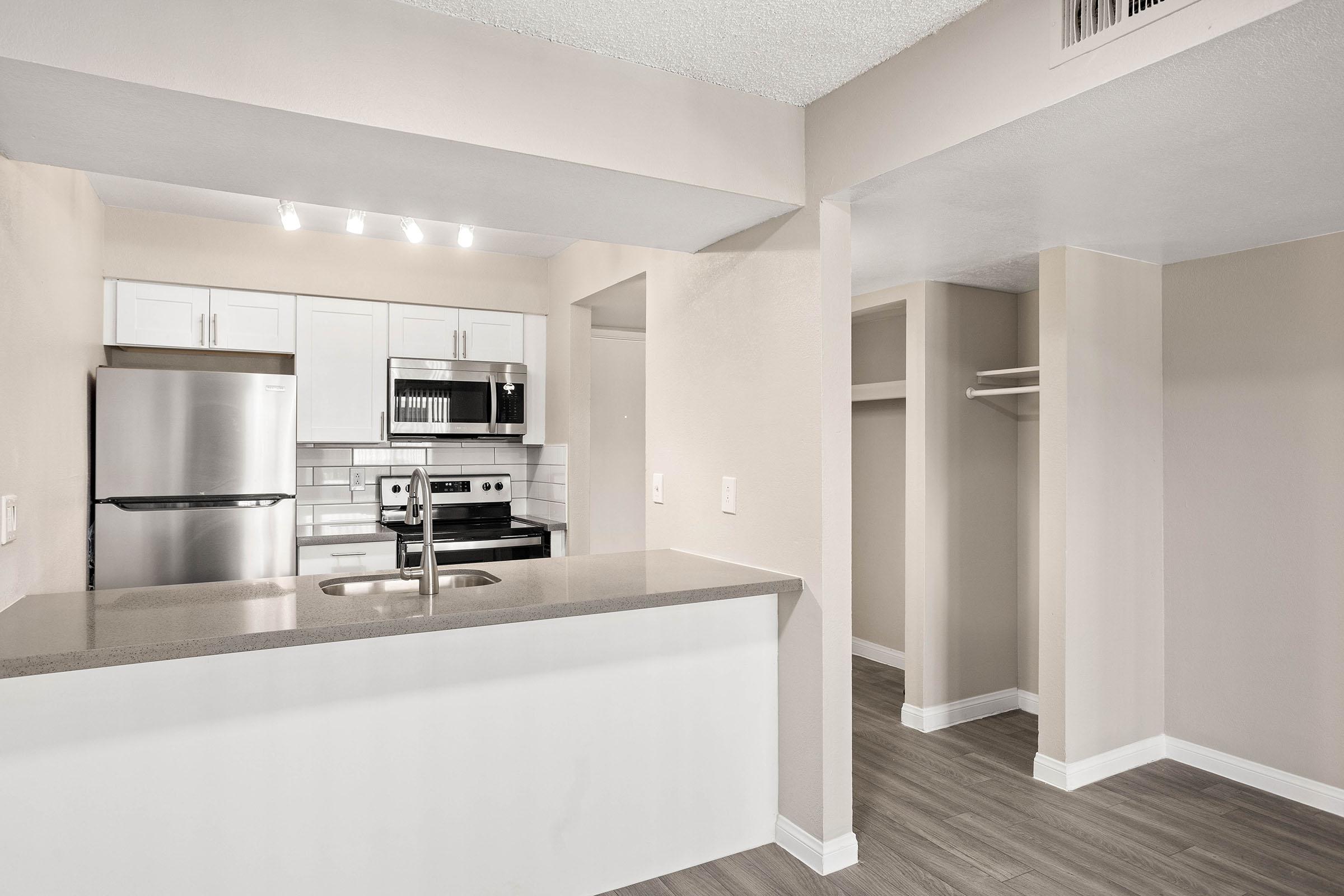Renovated kitchen with large quartz island and stainless steel appliances