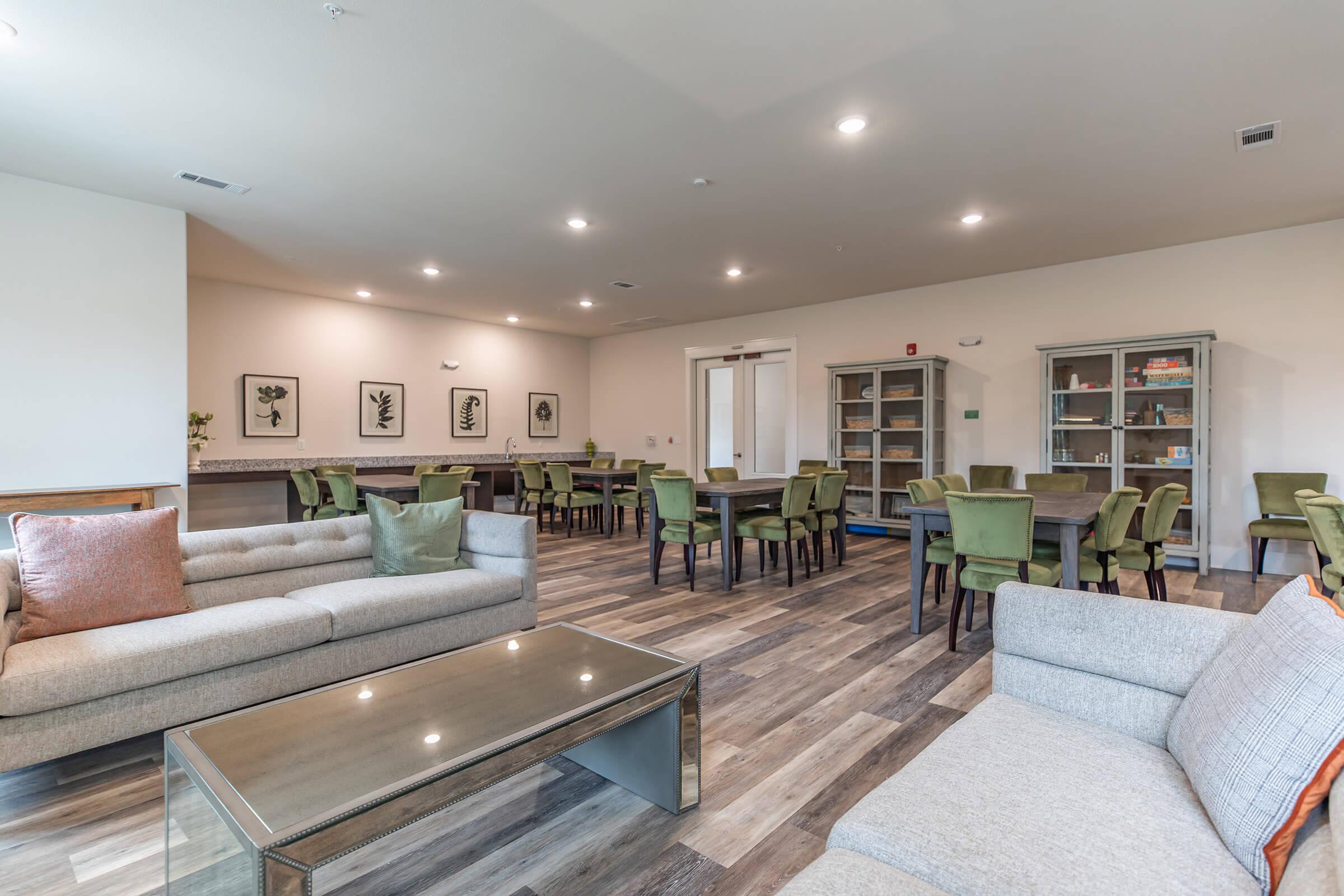 resident lounge at ivy point kingwood senior living apartments in kingwood tx featuring wood grain flooring and ample seating