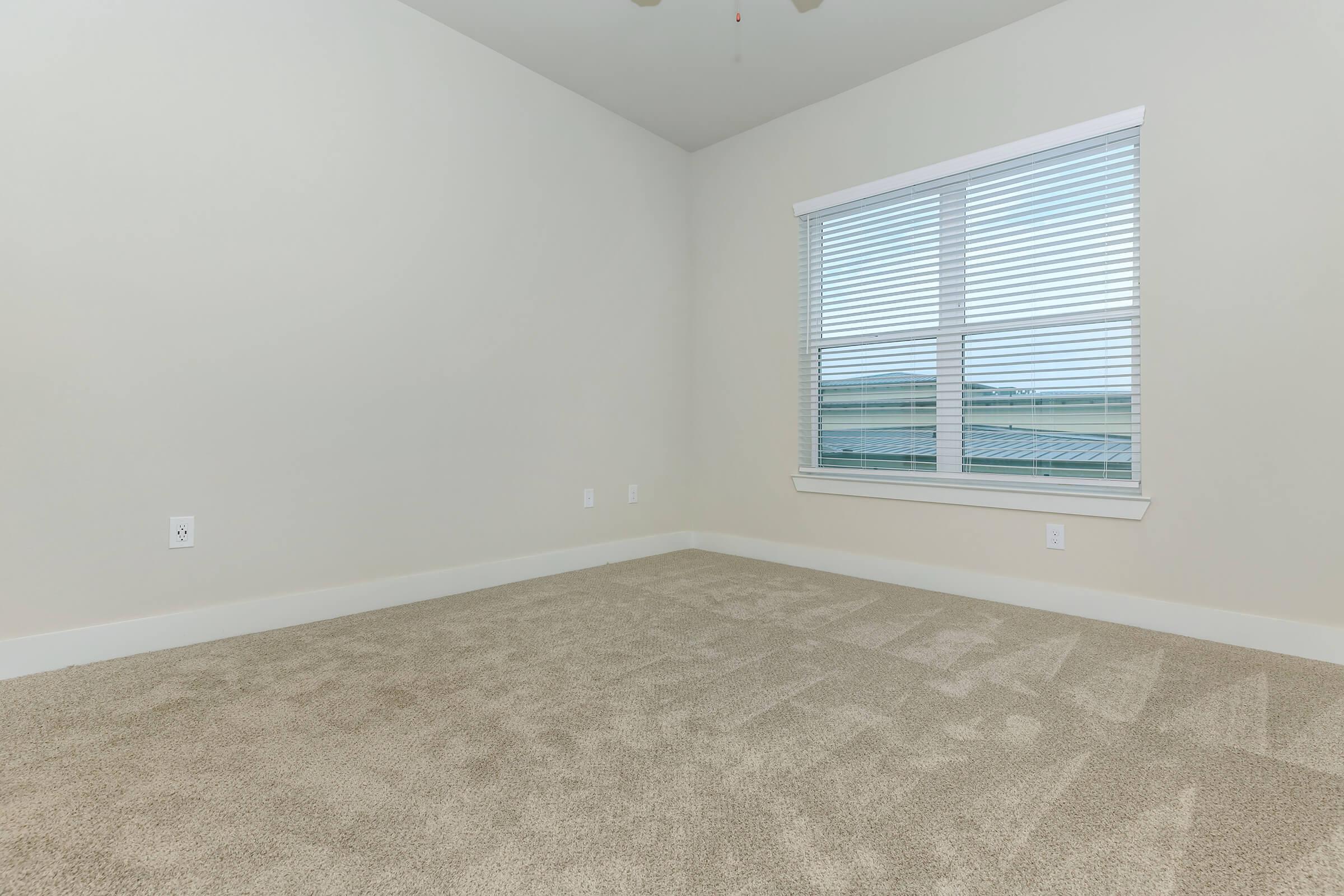 bedroom at ivy point kingwood senior living apartments in kingwood tx featuring carpeted flooring and windows with blinds