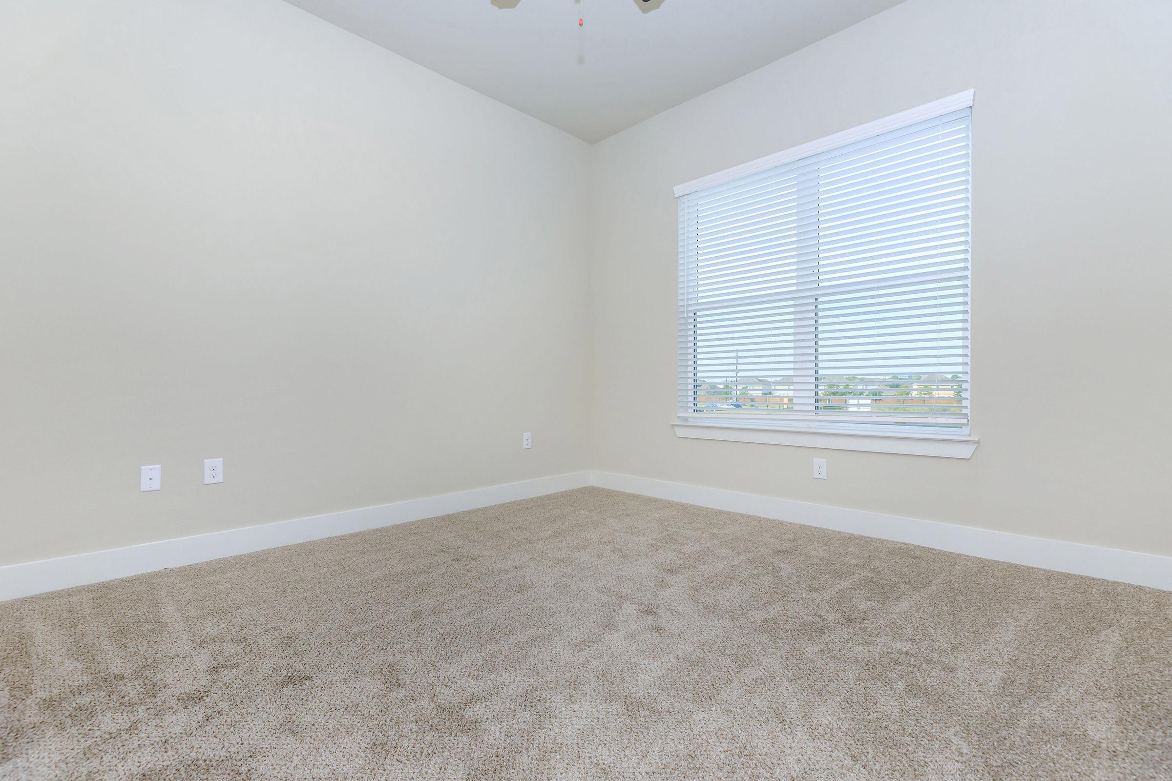 bedroom at ivy point kingwood senior living apartments in kingwood tx featuring carpeted flooring and windows with blinds