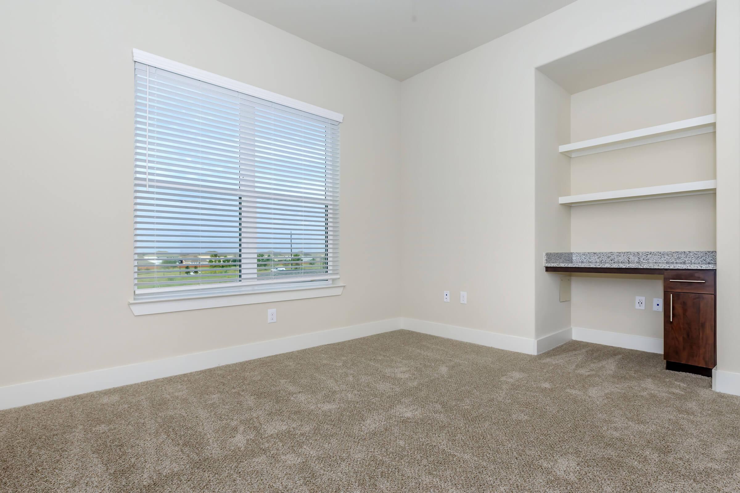 empty room at ivy point kingwood senior living apartments in kingwood tx featuring carpeted flooring and shelving